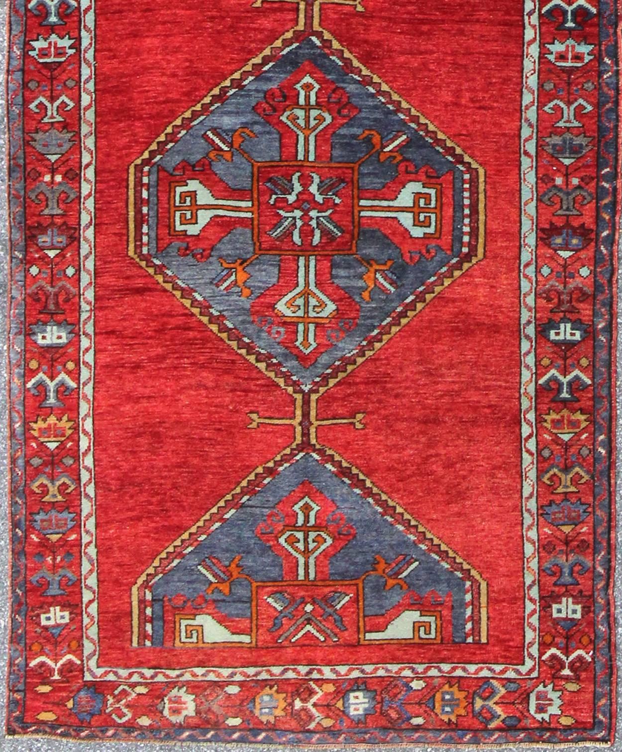Colorful Turkish Oushak Runner in Various Shades of Red, Blue, and Yellow, En-142354, 1940’s Vintage Turkish Oushak Gallery Rug
This Turkish Oushak runner features a central medallion design as well as patterns of smaller, geometric motifs. Colors