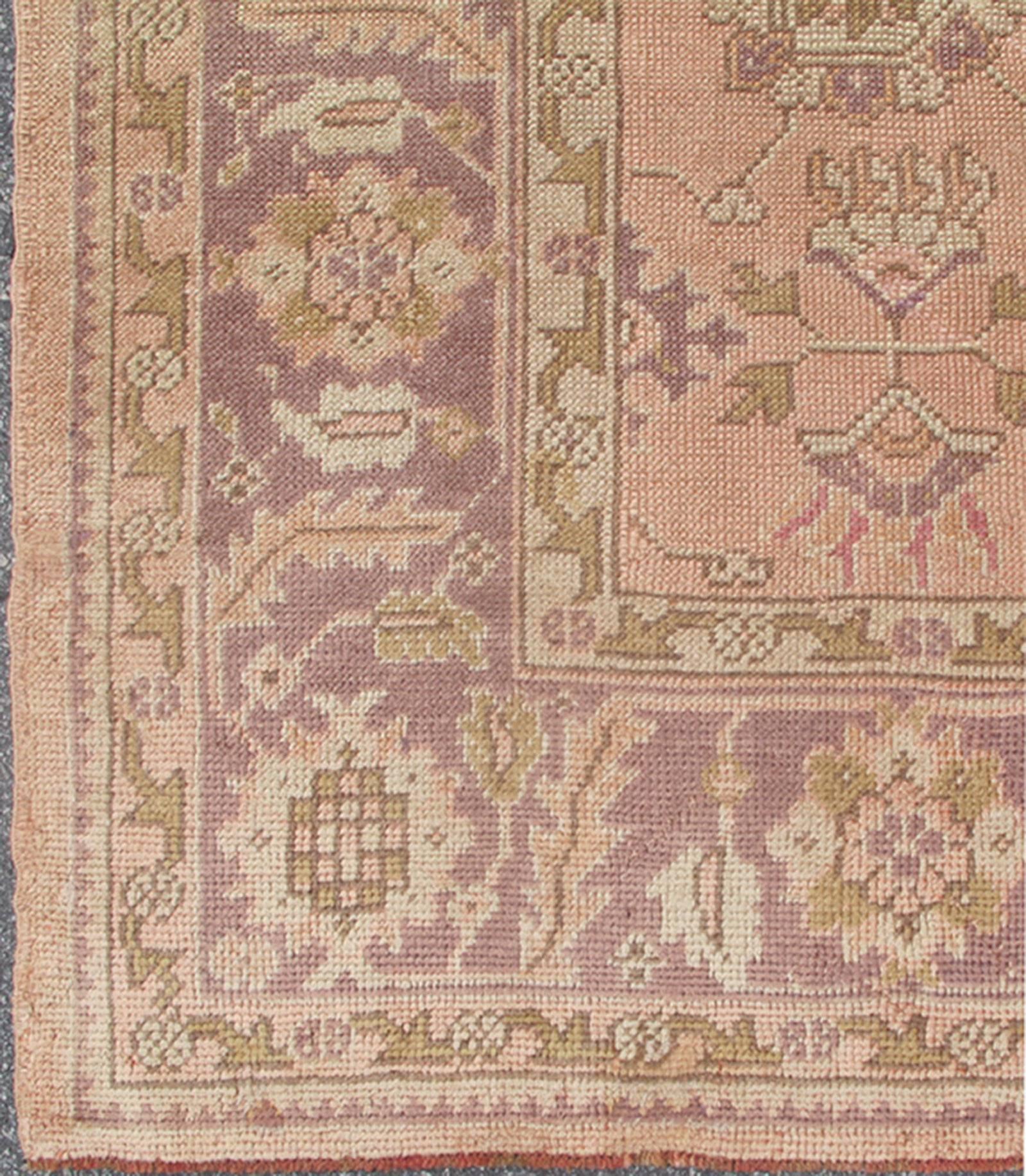 Antique Turkish Oushak Rug with Floral Motifs in Lavender, Coral-Pink, and Green. Keivan Woven Arts / rug L11-0406, country of origin / type: Turkey / Oushak, circa Early-20th century
Measures: 8'10 x 11'5.
This unique Turkish Oushak carpet features