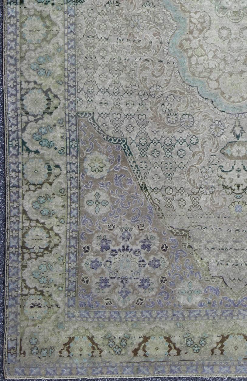 This beautiful rug from mid-20th century Turkey features a traditionally European design. The faint cream ground is home to the elaborate center medallion and surrounding floral motifs. The border, an extension of these motifs, is surrounded by two