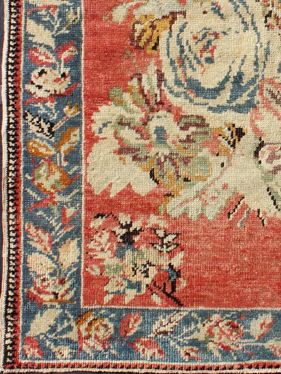 Measures: 3'9'' x 5'5''.
Inspired by antique Caucasian Karabagh, this handwoven vintage Oushak rug features a large bouquet of flowers in the central field, flanked by smaller bouquets in the four corners. The bouquets are brought to life on a faint