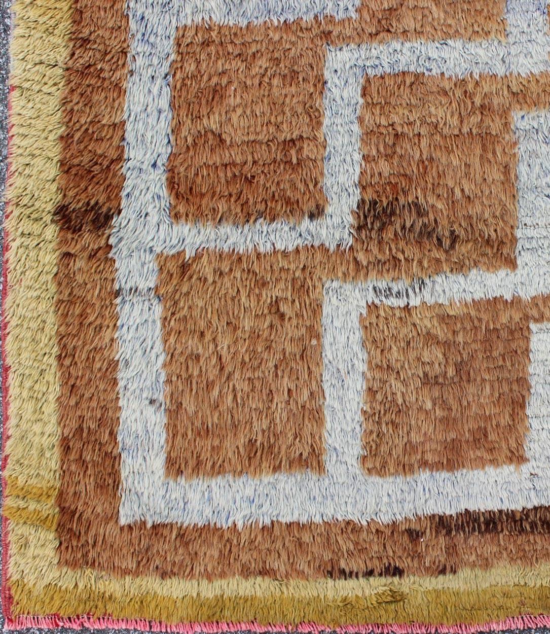 Ce Tulu vintage du milieu du 20e siècle en Turquie présente un motif tribal interconnecté. Le motif à plusieurs niveaux se compose de contours ivoires sur un champ orange clair. Le contraste des couleurs ajoute une profondeur particulière qui