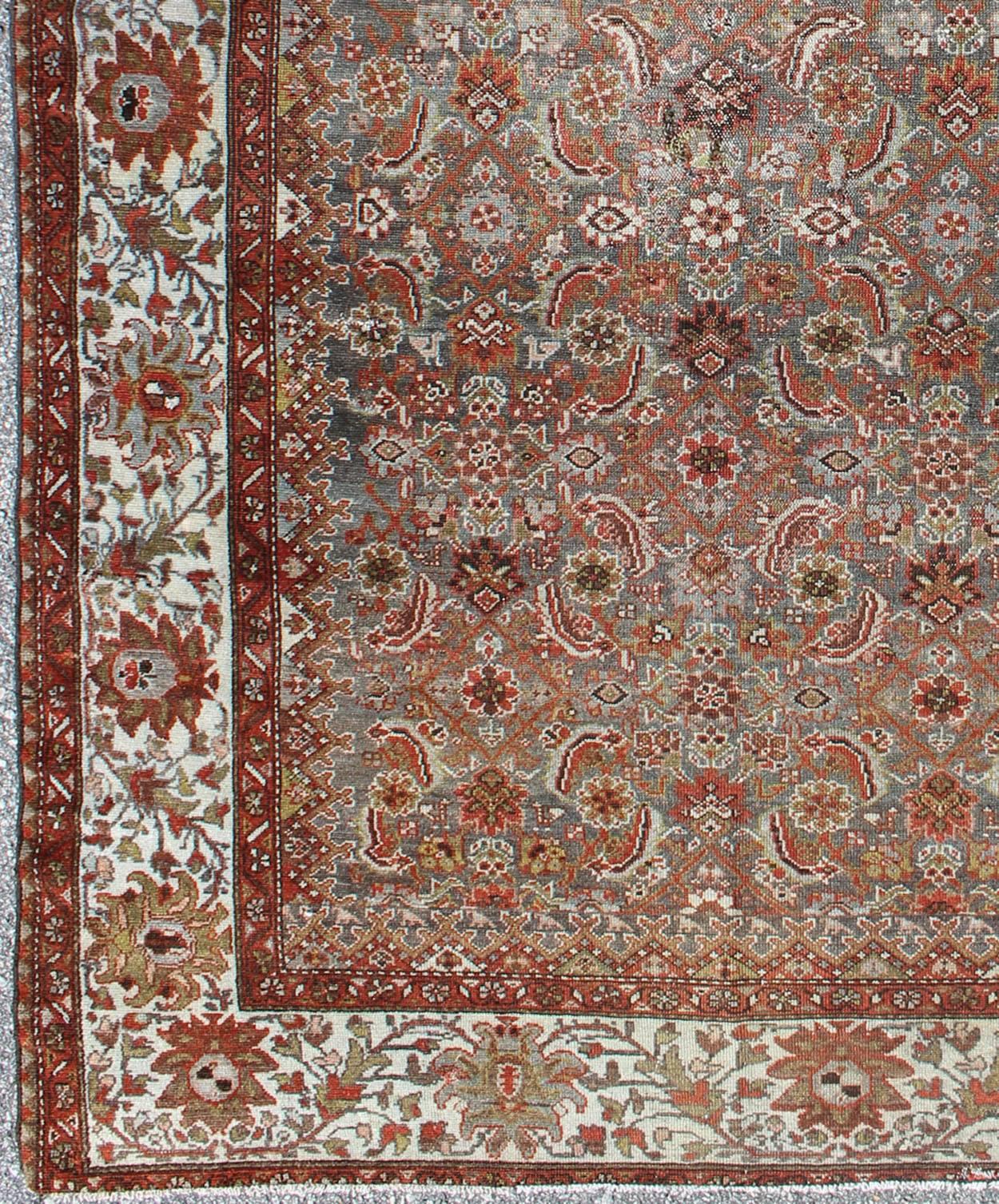 Dieser prächtige antike persische Malayer-Teppich zeigt ein wunderschönes subgeometrisches Allover-Muster, gepaart mit einer reizvollen Farbpalette aus verschiedenen Schattierungen von Hellblau, Tiefrot und Taupe. Das zentrale Feld ist mit