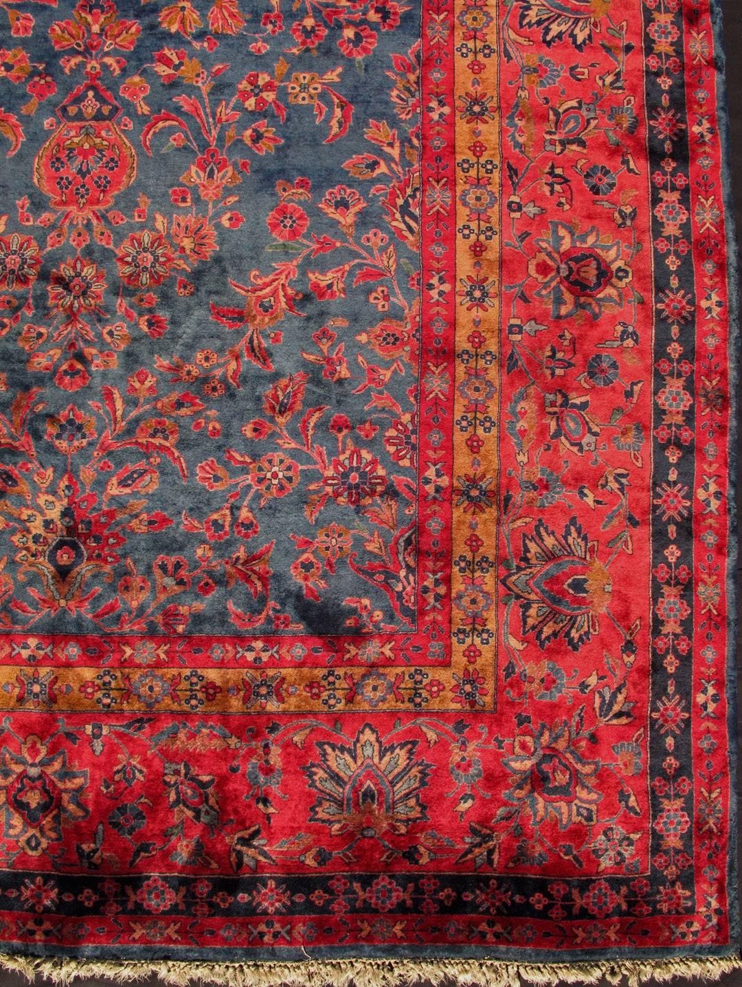 Distinct colors that are similar yet starkly rendered flow alongside each other in this gorgeous antique rug. Bright red sets the attractive background for the largest border, which is outlined by two thinner borders. Within the frames are flowing