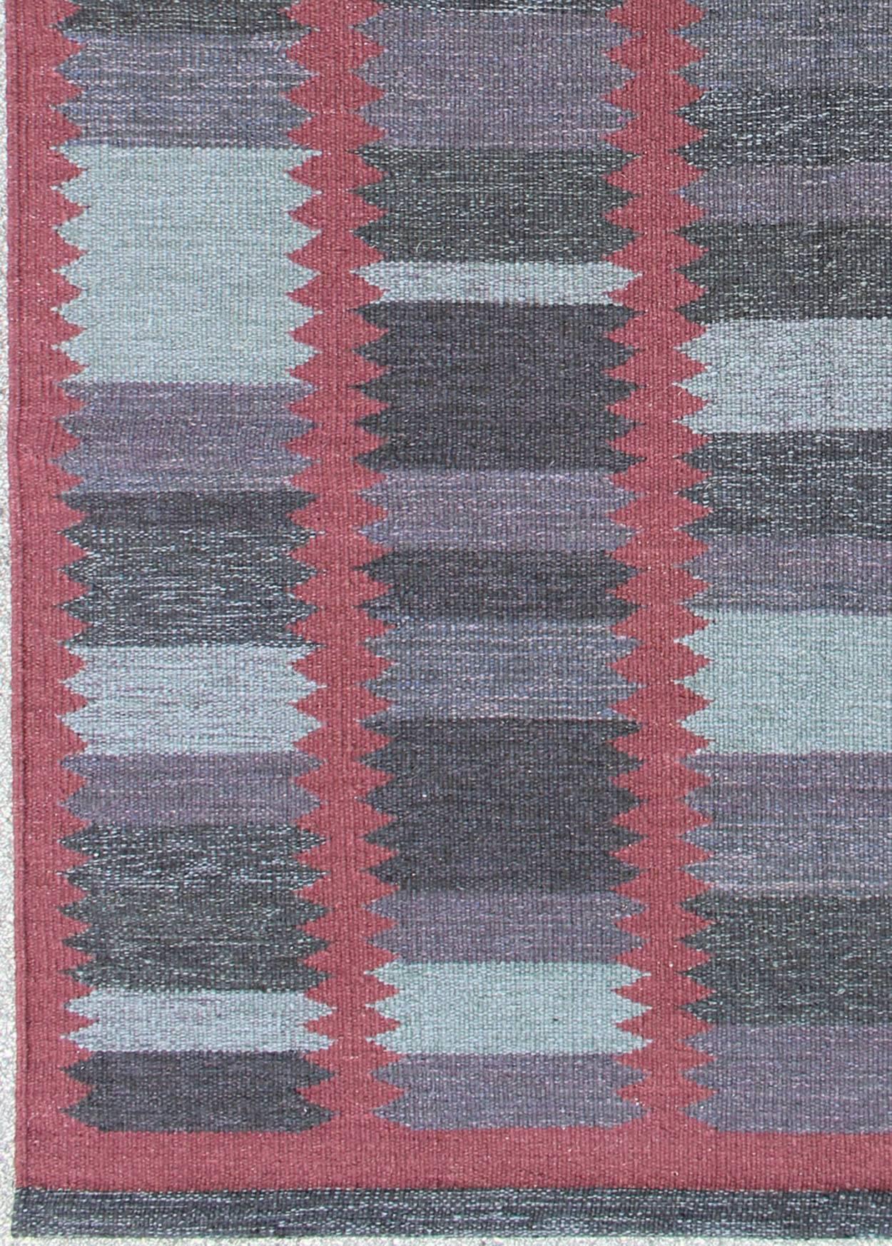This Scandinavian flat-weave patterned rug is inspired by the work of Swedish textile designers of the early to mid-20th century. With a unique blend of historical and modern design, this dynamic and exciting composition is beautifully suited for