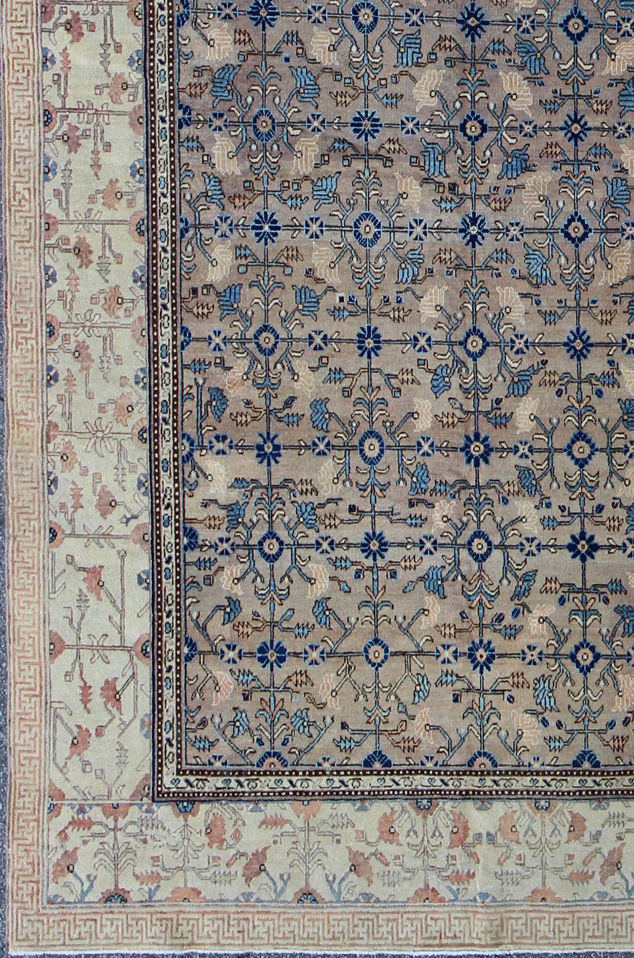 This attractive antique Khotan rug is a spectacular testament to the complexity of Turkestan design. The gray central field plays host to a stunning display of entwined blossoms and botanical elements. The complementary border is a testament to the