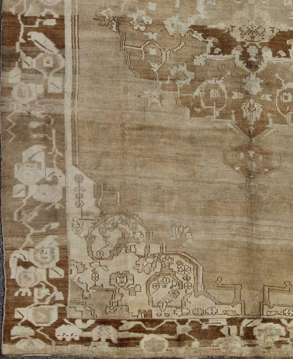Brauner, hellbrauner und elfenbeinfarbener türkischer Oushak-Teppich mit floralem Mittelmedaillon, Teppich ars-538, Herkunftsland / Art: Türkei / Oushak, um die Mitte des 20. Jahrhunderts

Dieser alte türkische Oushak-Teppich (ca. Mitte des 20.