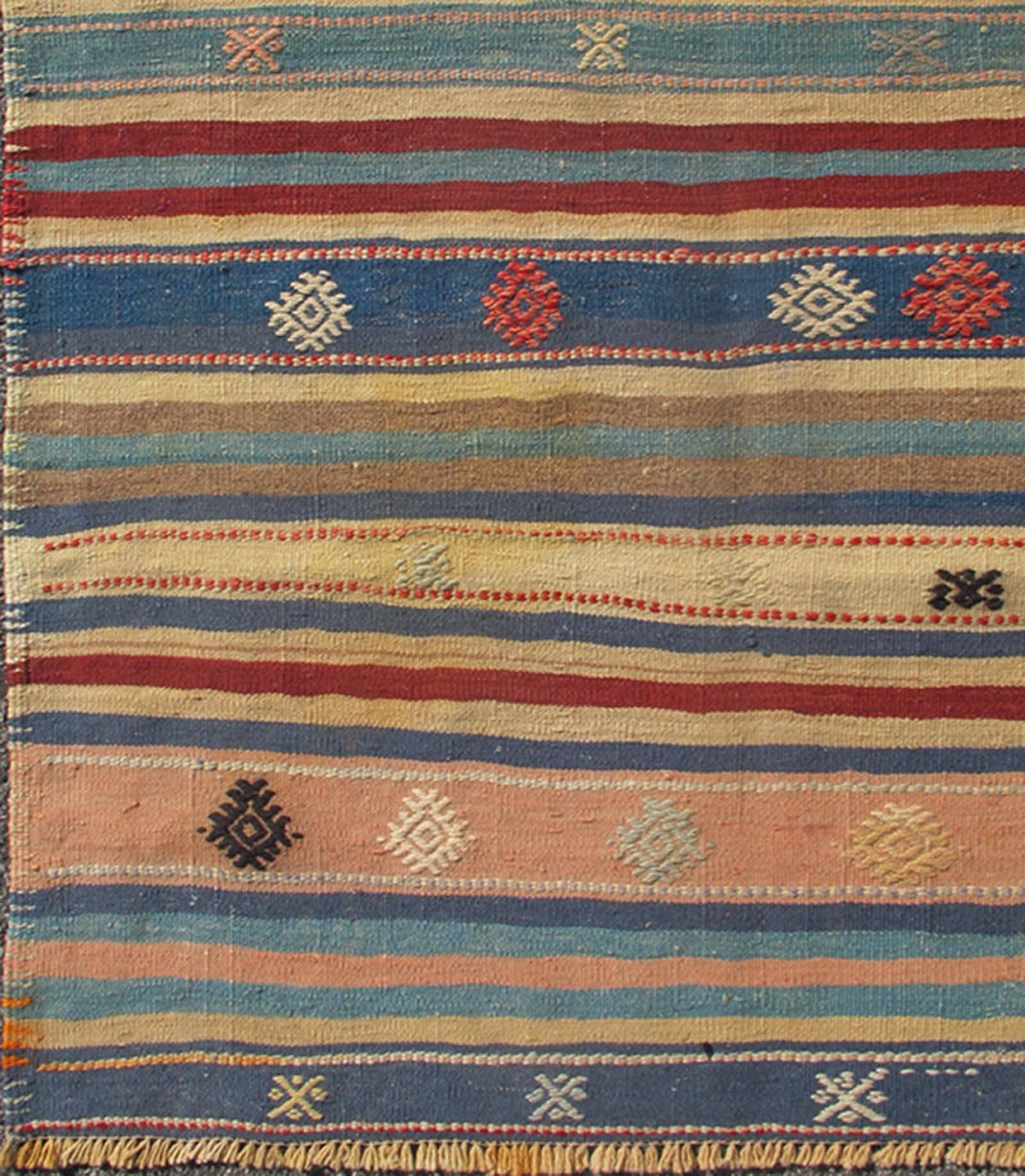 Colorful vintage Turkish Kilim rug with horizontal stripes and tribal designs, rug emd-136530, country of origin / type: Turkey / Kilim, circa mid-20th century

Featuring tribal shapes with a spotted and speckled assortment of geometric elements,