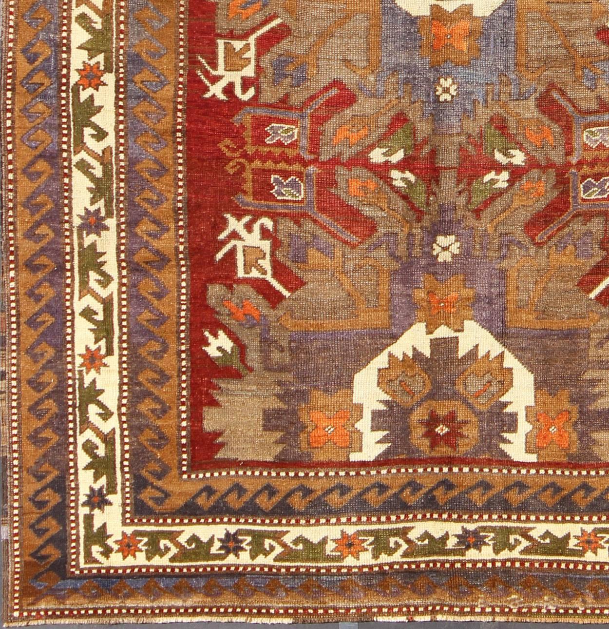 Measures: 7'8'' x 10'3''.
This vintage Turkish Oushak gallery rug (circa mid-20th century) features a unique blend of colors and an intricately beautiful design. The central medallions (one full and one half) are surrounded by complementary figures