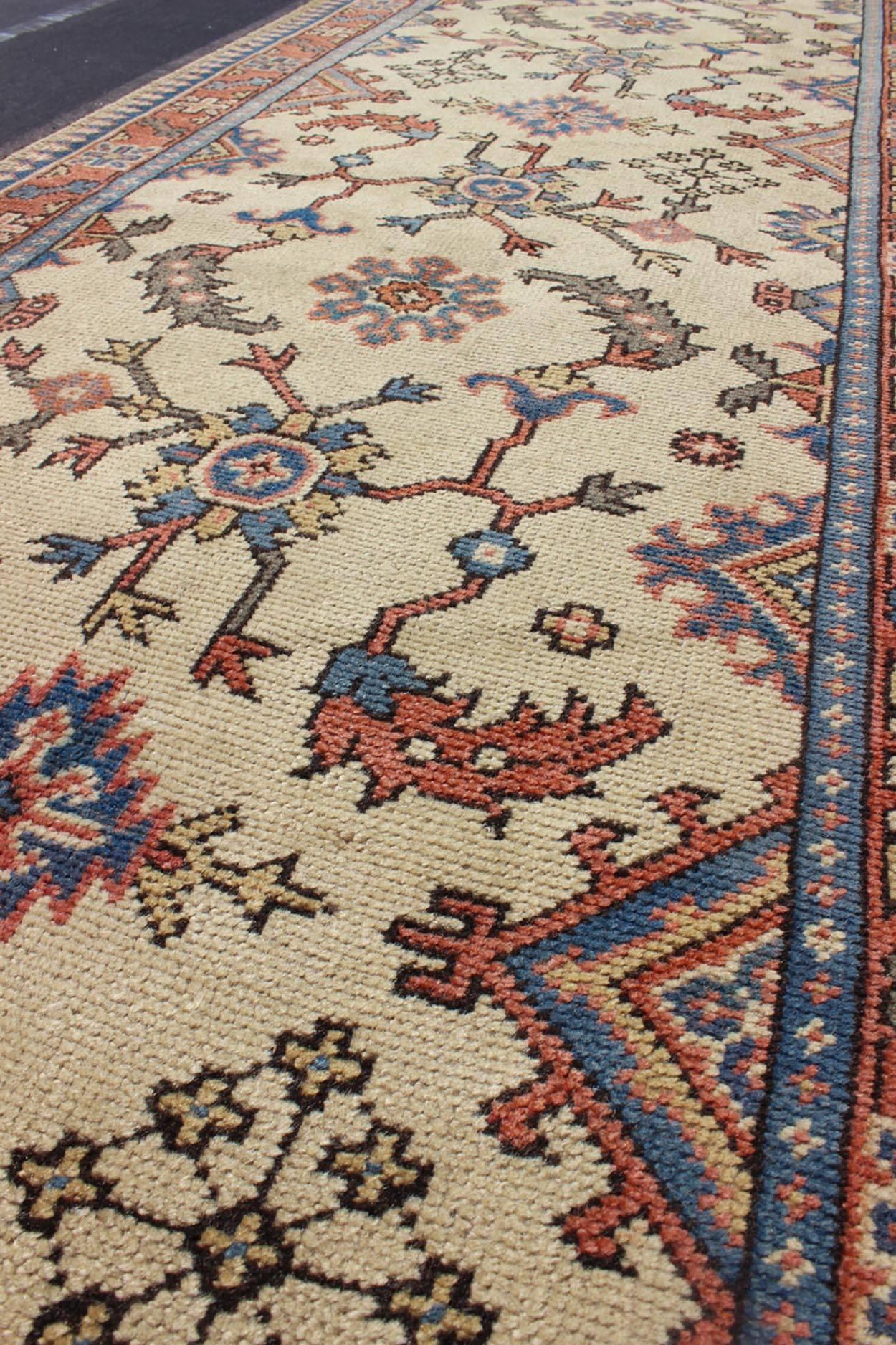 Mid-20th Century Long Turkish Oushak Runner with All-Over Design in Cream, Coral Red and Blue For Sale