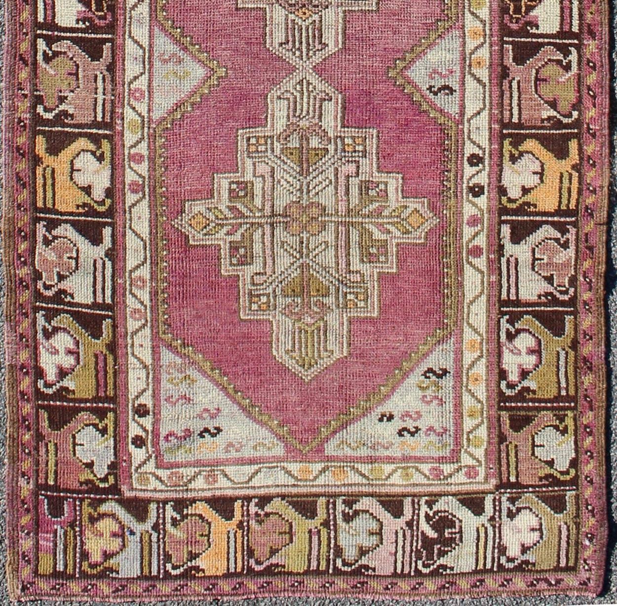 Vintage Oushak Runner with Geometric Medallions in Purple and Brown.
This unique Oushak short runner bears a remarkable geometric design that is complemented by a delicately understated color palette. The purple background plays host to an