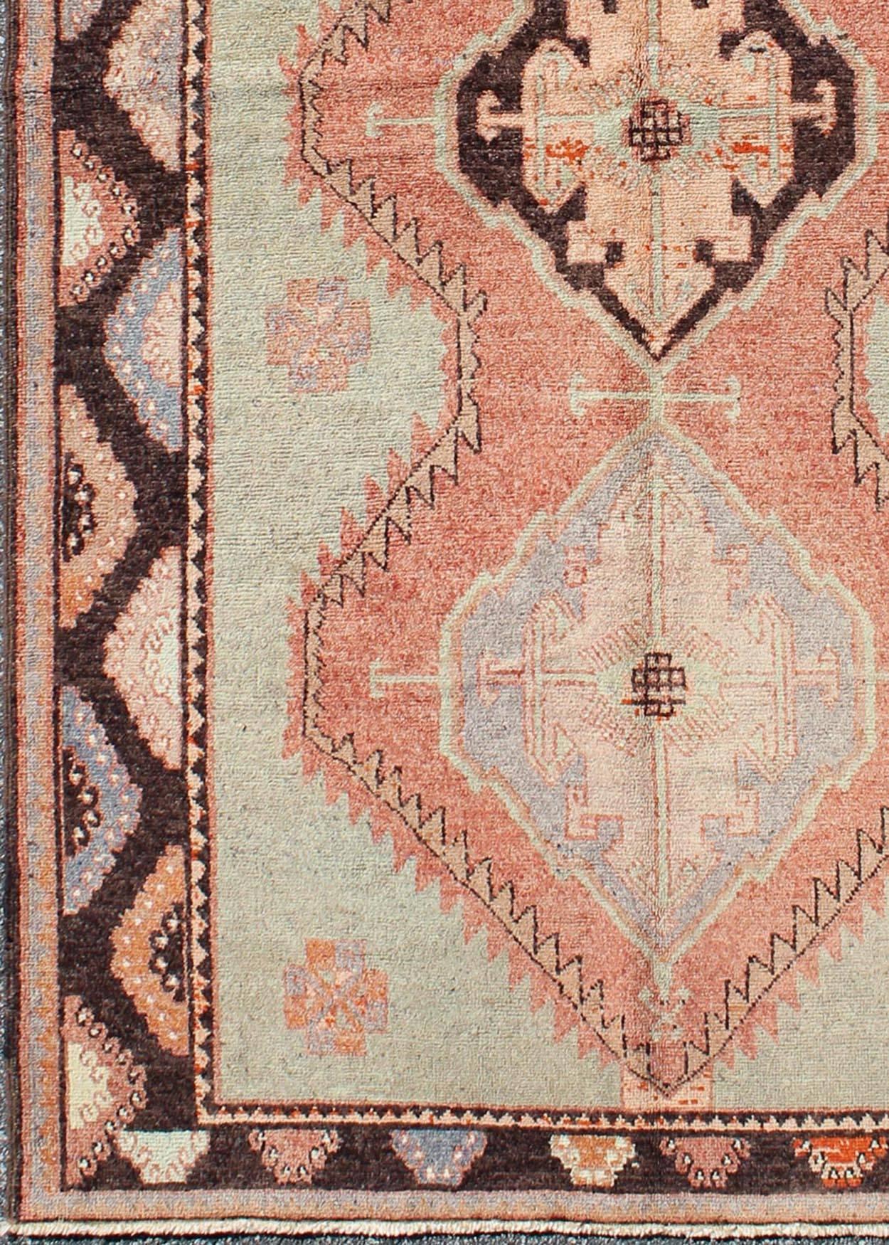 Turkish Oushak Rug with Geometric in Tangerine, Green and Brown.
This soft color Oushak carpet rests beautifully upon a field of elegant green and tangerine. Three medallions take center stage and are well balanced with a border of cast green,