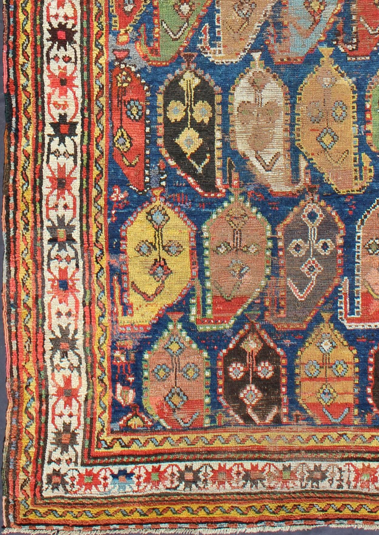 Amazing Antique Caucasian rug with Large Paisley Design in Blue Background.
This early antique Caucasian displays repeating large-scale paisleys surrounded by multi-tiered borders. Set on an indigo background, this piece has vivid and rich colors.