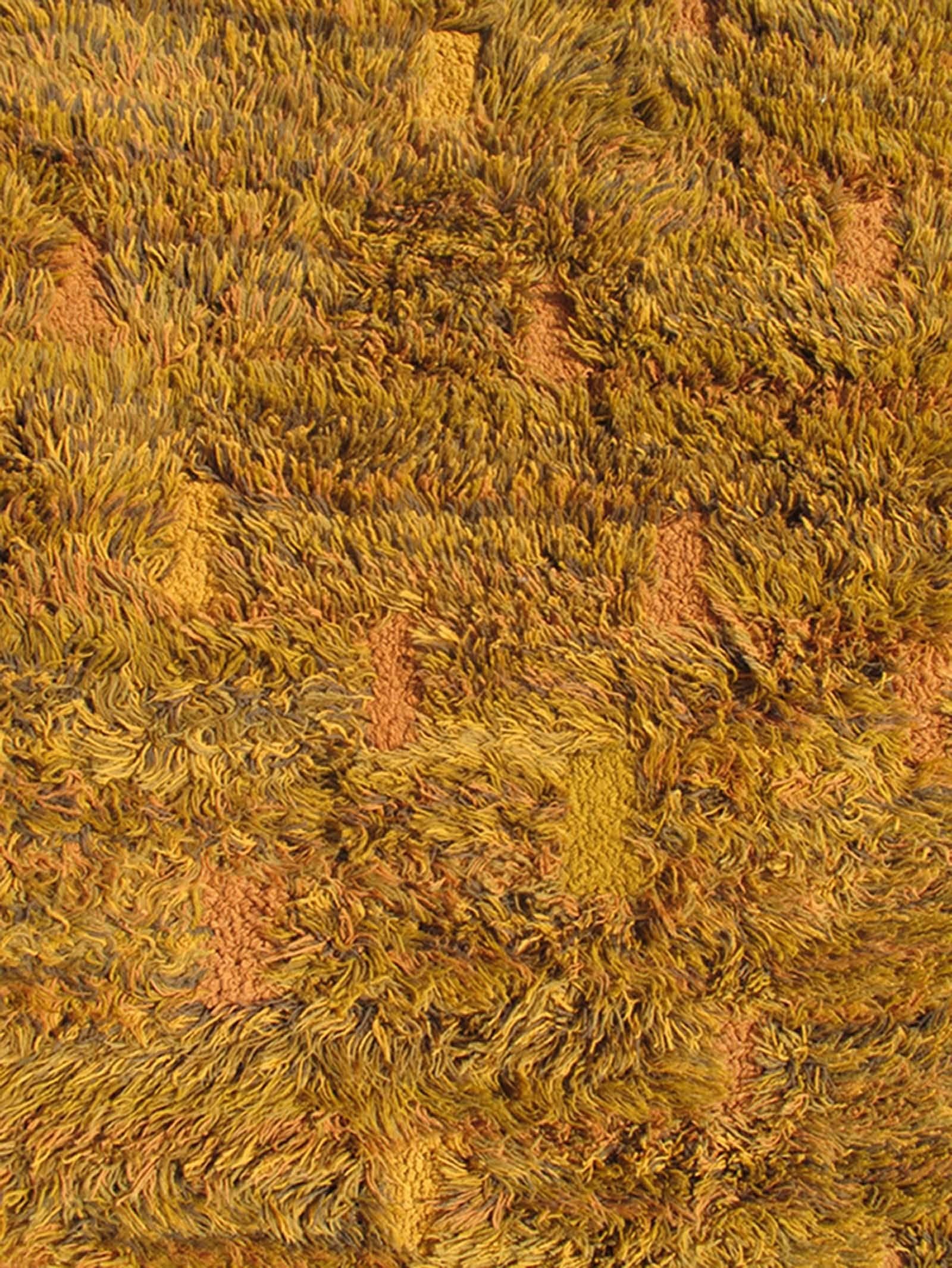 Vintage Modern Design rug with Shag Pile in burnt orange, brown and green tones.
This particular vintage rug features a beautiful blended modern design, inspired by nature in conjunction with an array of s wheat tones with brown and orange
