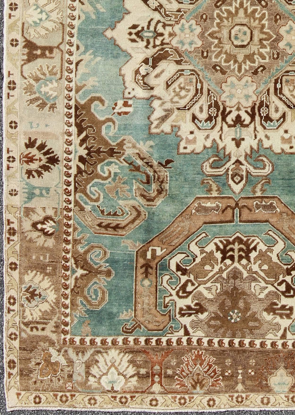 Set on a unique turquoise field, this stunning Turkish rug displays a bold design with shades of brown, taupe, ivory, sea-foam green and other neutrals. These stunning combinations render this rug a marvelous fit for a wide variety of