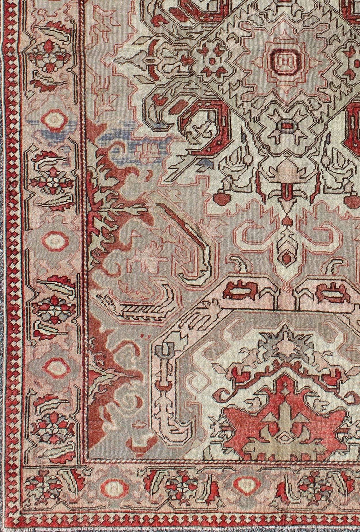 Sevas/Sivas rugs from western Anatolia are renowned for their fine weaves and intricate designs. Set on a taupe and warm grey background, this outstanding small rug displays a variety of reds, pale green and soft pink, with highlights of grey and