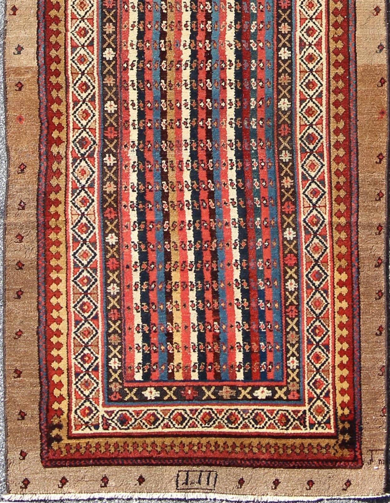 Measures: 3'7 x 11'3.
The stirring composition of this exemplary runner is characterized by a tribal pattern and brilliant colors. A series of smaller symbols appear throughout the runner, arranged in an alluring asymmetrical pattern. A beautiful