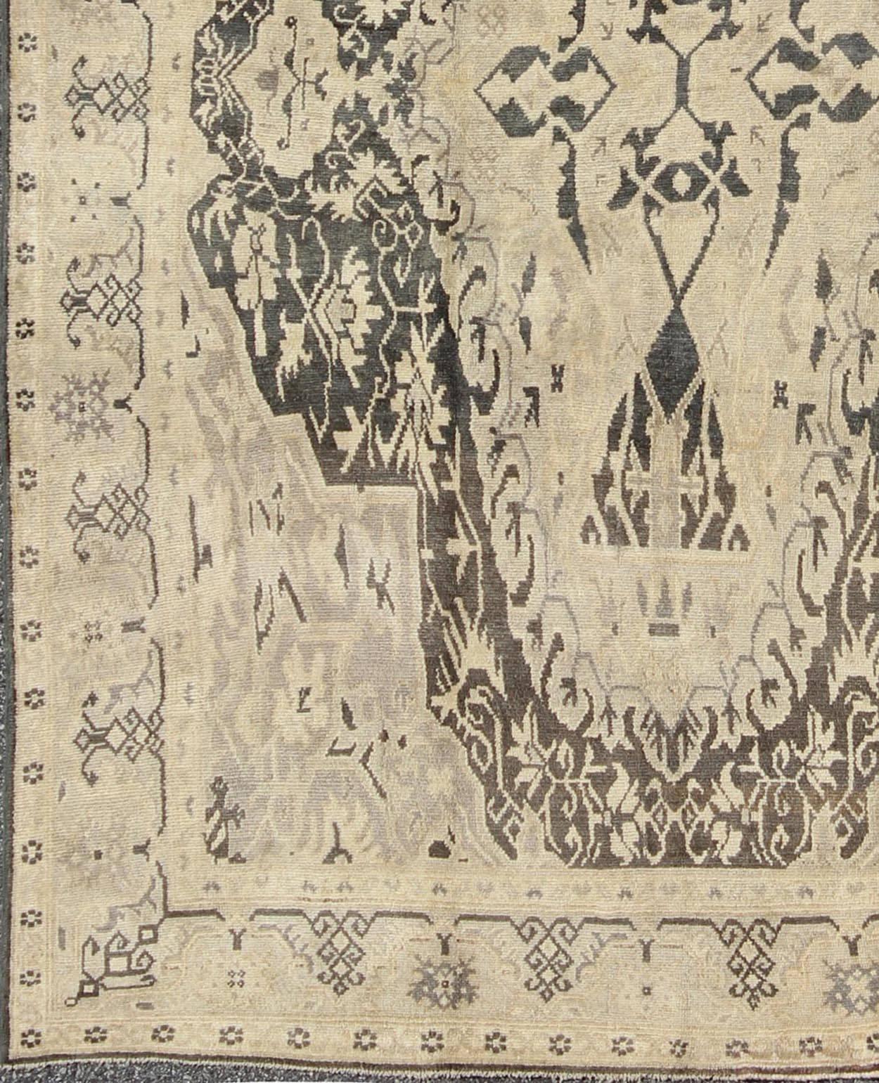 Set on a deep gray green background, this fabulous antique Turkish Sevas showcases a large and bold medallion surrounded by flowers and branches. The intricate design and delicate details allow the eye to fully capture the beauty of the rug. The