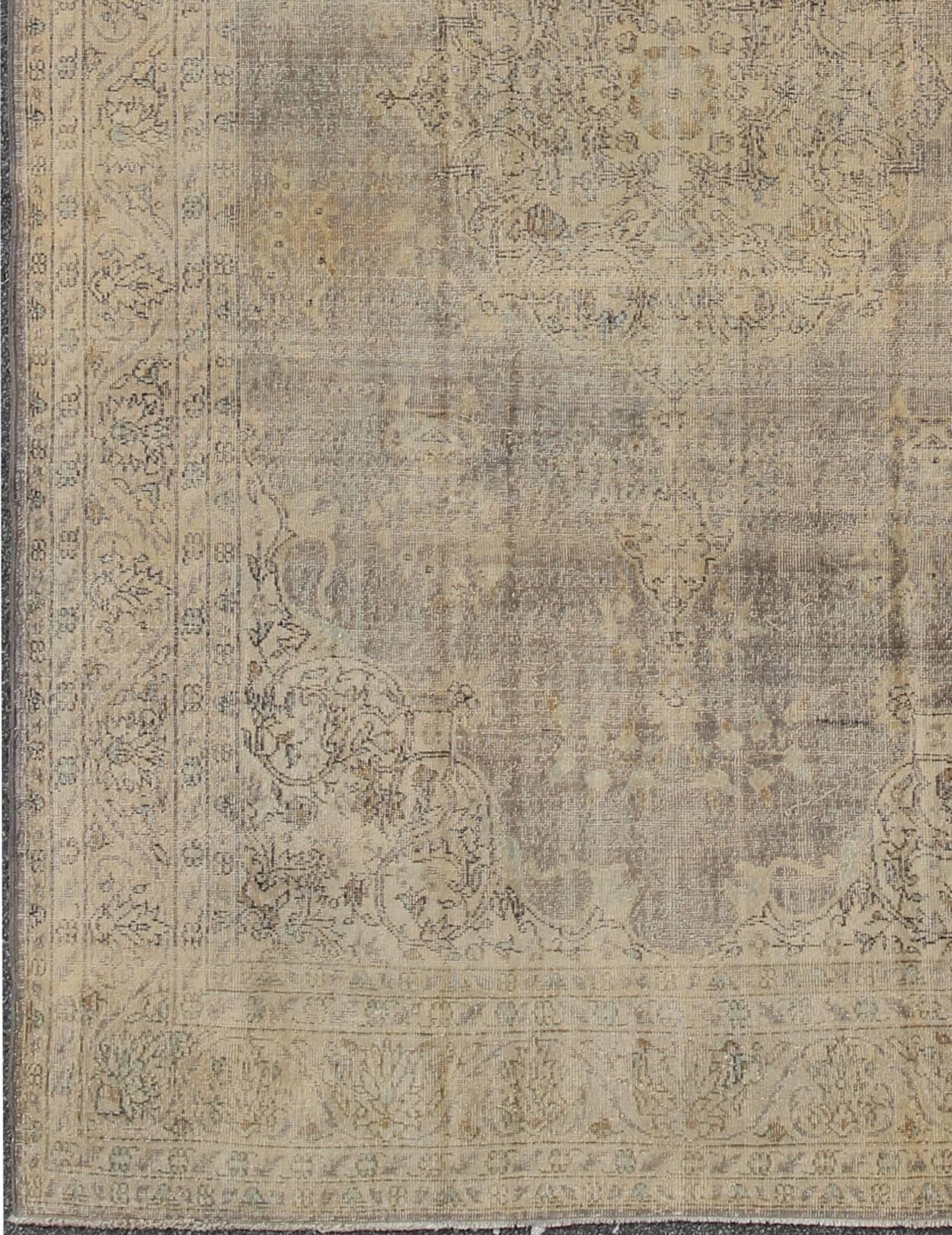 Distressed Turkish Carpet with Floral Design in Taupe, Gray, Brown and Ivory.
This vintage Turkish carpet has been neutralized to create faded pigments with a floral design. Neutral colors include many shades of taupe, gray, and ivory, with brown