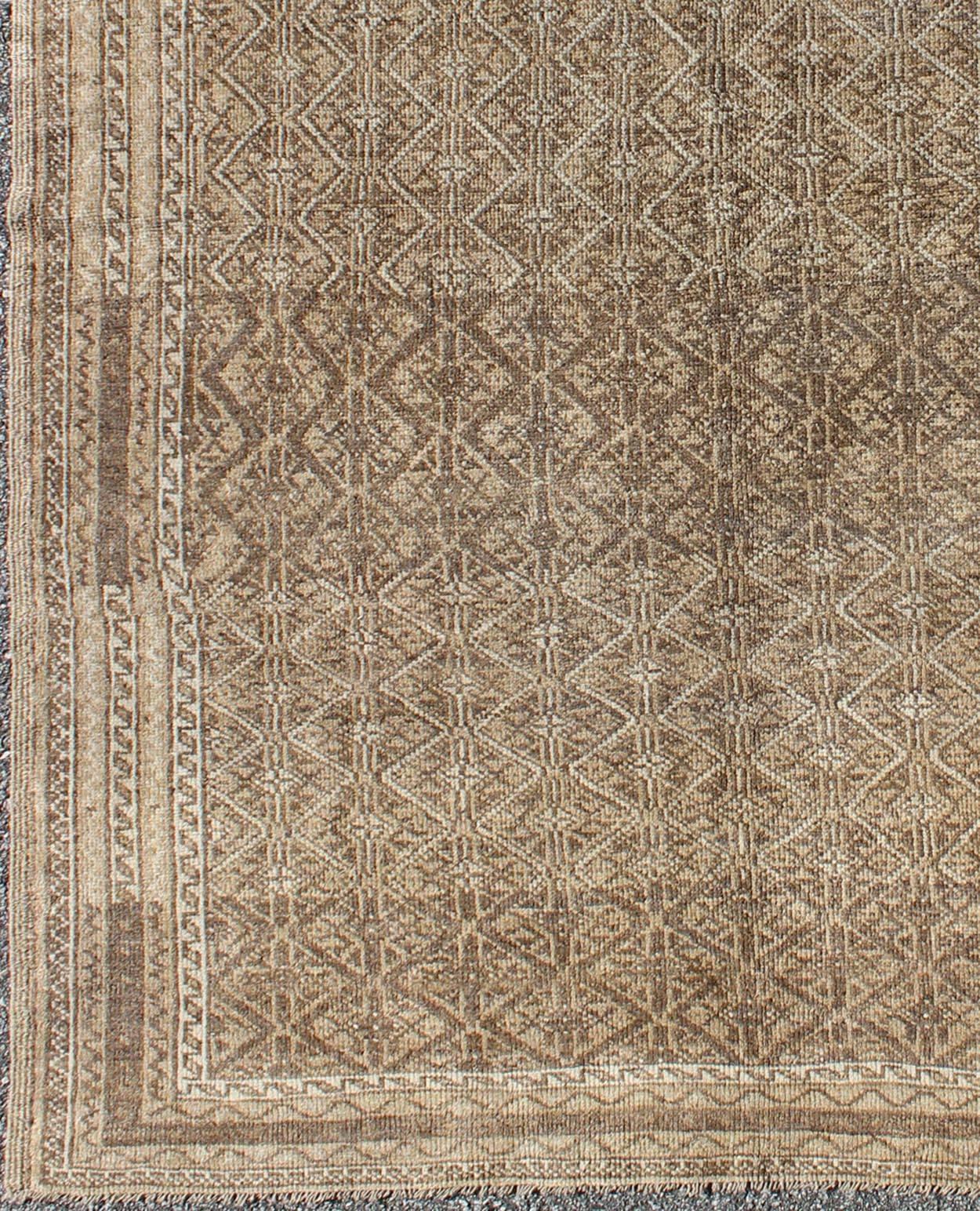 Unique Turkish Rug with Brown and Neutral Colors.
This piece is an impressive patterned and geometric rug that was handwoven during the first part of the 20th century in Turkey. With an all-over diamond and lattice design, the color palette and