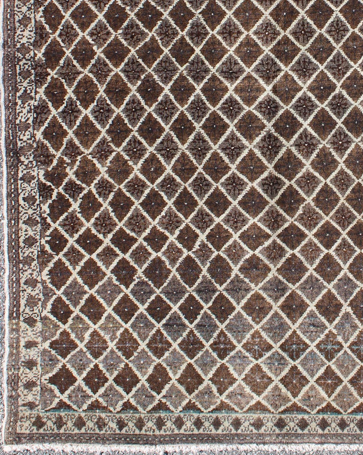 Turkish Rug with Modern Diamond Design in Brown Colors.
This vintage Mid-Century Turkish rug features a contemporary design on a predominantly chocolate-brown background with ivory outlines.
Measures: 3'9 x 5'4.