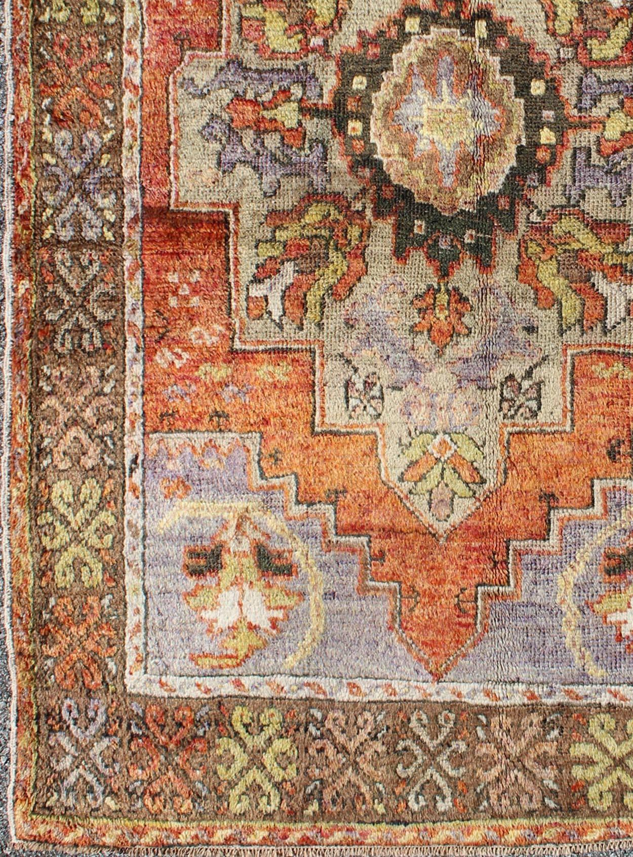 Vintage Colorful Turkish Oushak Rug in Orange, Purple, Green and Brown.
This piece a compelling and beautifully woven Oushak carpet that was made in Turkey during the middle of the 20th century. This vintage carpet beautifully communicates an