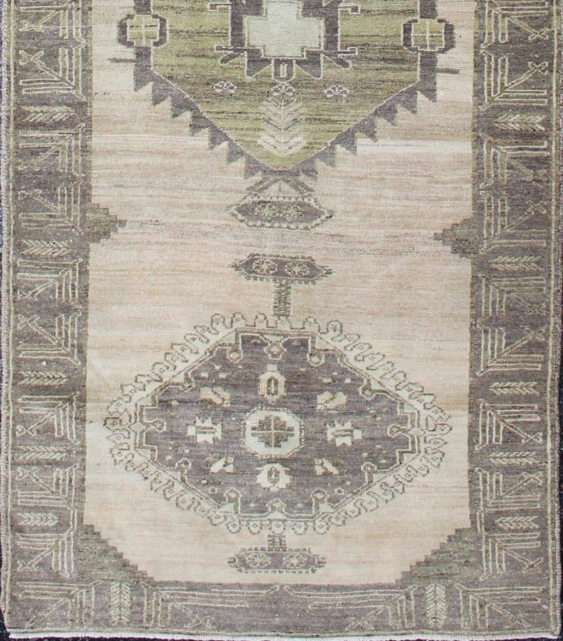 Vintage Oushak Runner Influence by Ottoman Designs in Neutral Colors
This fine runner from the Oushak region of Turkey features evenly-colored field with a unique fragmented spandrel in a characteristically subdued color scheme. In addition to guard