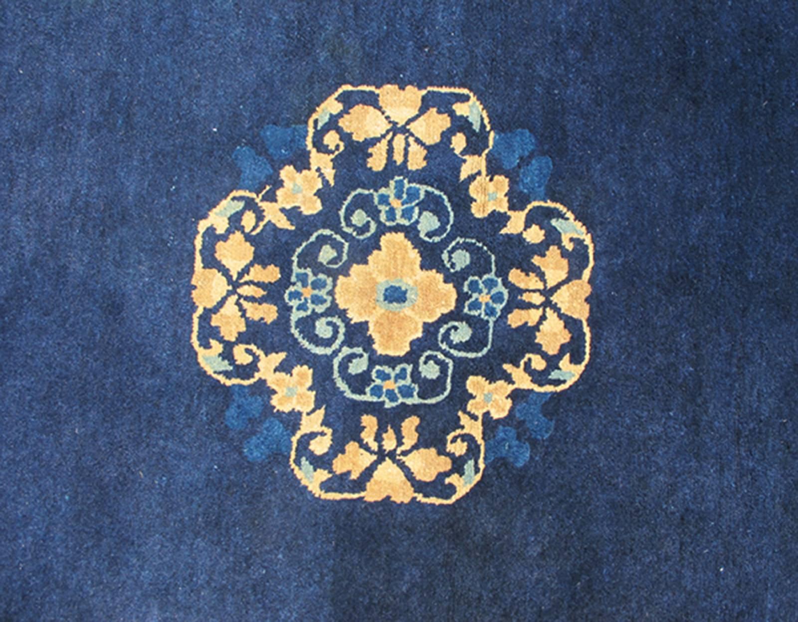 Antique Chinese Peking Carpet in Dark Blue Background S12-0510, 1920’s Antique Chinese Peking Rug- 4' X 6'8
The saturated blue field of this piece forms a vibrant backdrop for a medallion with four-corner lotus blossom flowers, which were symbols of