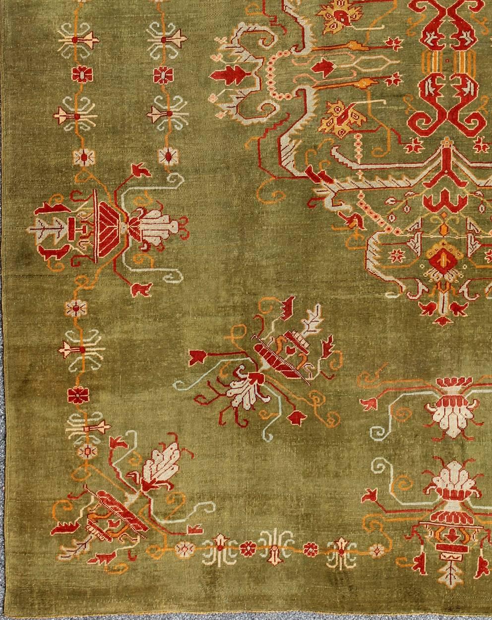 Antique Turkish Oushak Rug in Green Field and Colorful Accents. Keivan Woven Arts Rug / 13-1214, Green Antique Oushak, antique green Oushak. 
Measures: 12'2 x 14'8
This striking Oushak showcases a unique  pattern of stylized large flowers on a rich