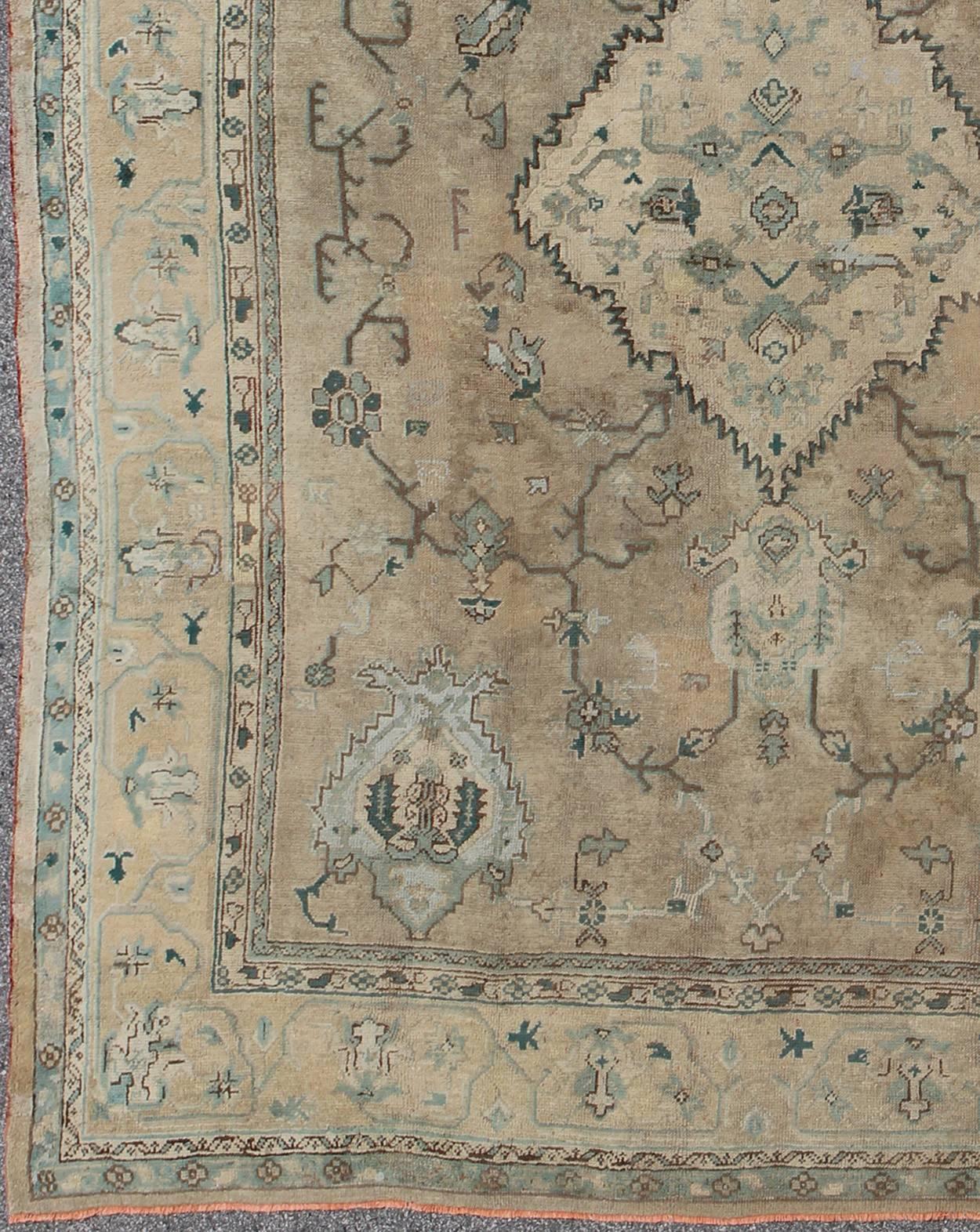 Neutral antique Oushak carpet in shades of teal, green, khaki, taupe and butter yellow. Keivan Woven Arts /  kwarugs /rug na-54747, country of origin / type: Turkey / Oushak, circa Early-20th century
Measures: 11'4 x 14'3.
This softly muted turn of