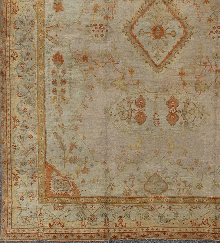 Antique Turkish Oushak Rug in green, Yellow, blush, apricot and light blue.
This impressive antique Oushak, composed of organic motifs and an exquisite array of soft colors, will bring an impressive amount of beauty and refined sophistication to any