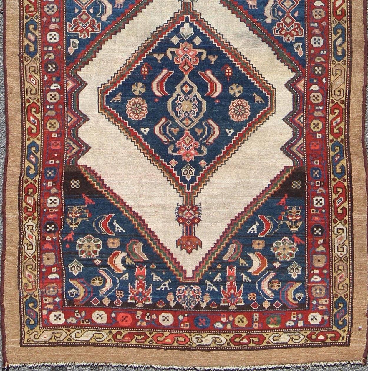 This rare Antique Serab runner from the late 19th Century contains beautiful multi-colored dual medallions set within a contained border of cream. This is surrounded by a delightful field of blue, containing patterns of flowers, plants, moons and