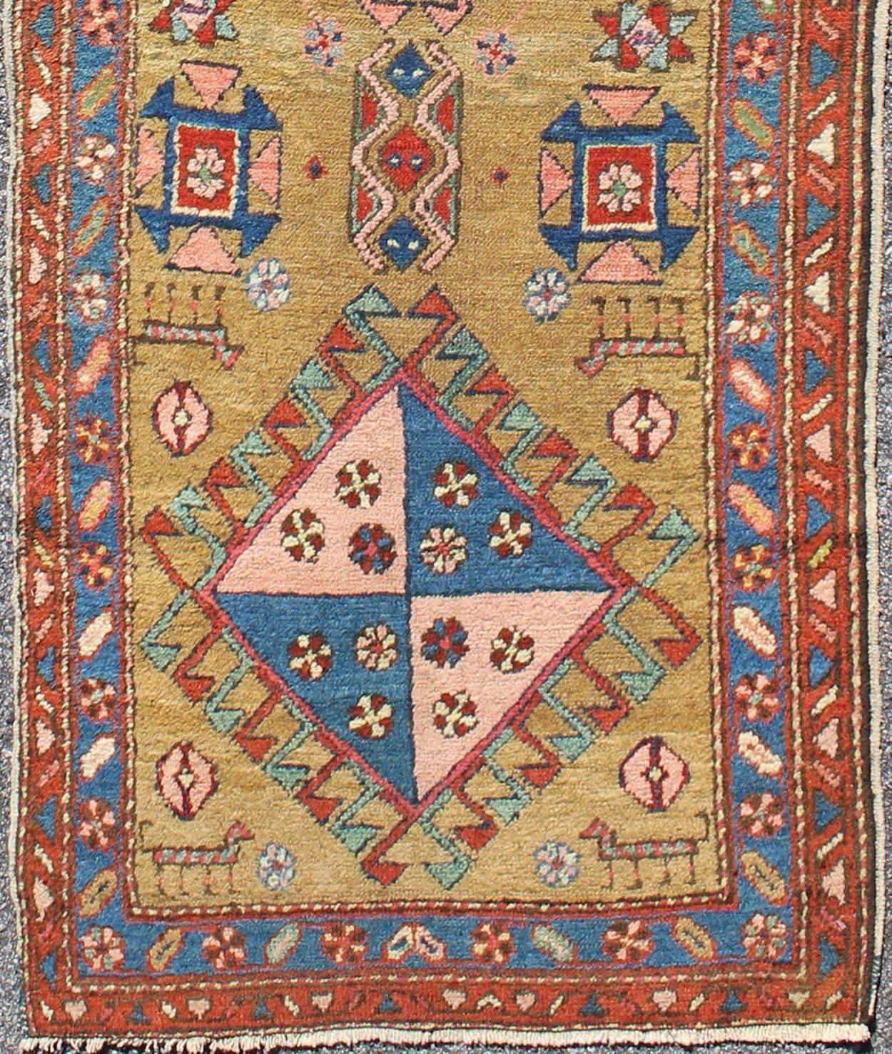 Antique Persian Serapi Short Runner in Gold & Yellow Background.
This antique Serapi-Heriz displays a charming and rich combination of various jewel colors. The geometric diamond shapes are repeated in different forms and colors throughout the