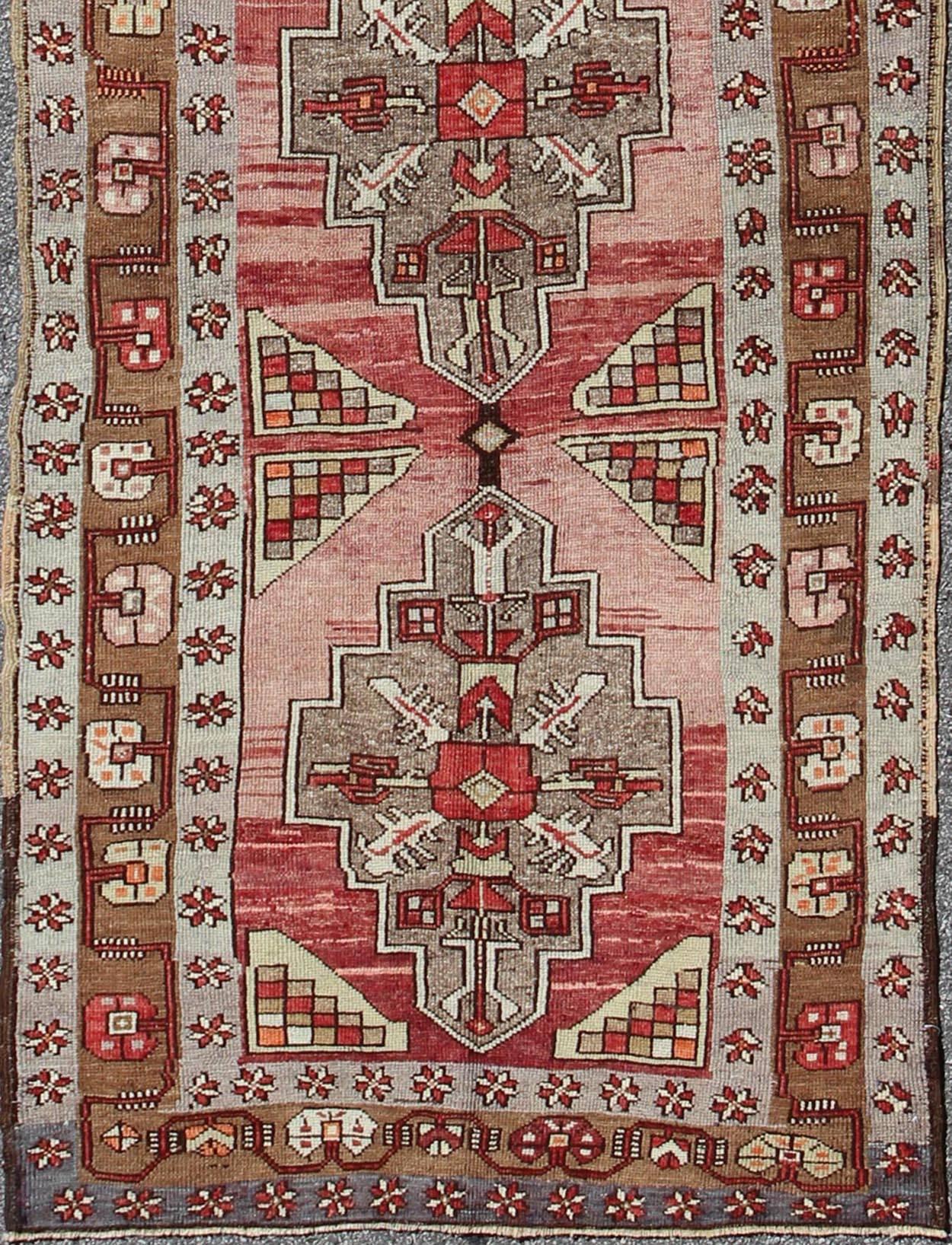 Measures: 4'2 x 14'0.
This vintage Oushak runner contains a unique blend of cheerful colors and an intricately beautiful design. The multi-layered diamond medallions are complemented by a symmetrical set of floral motifs. The various shades of teal,