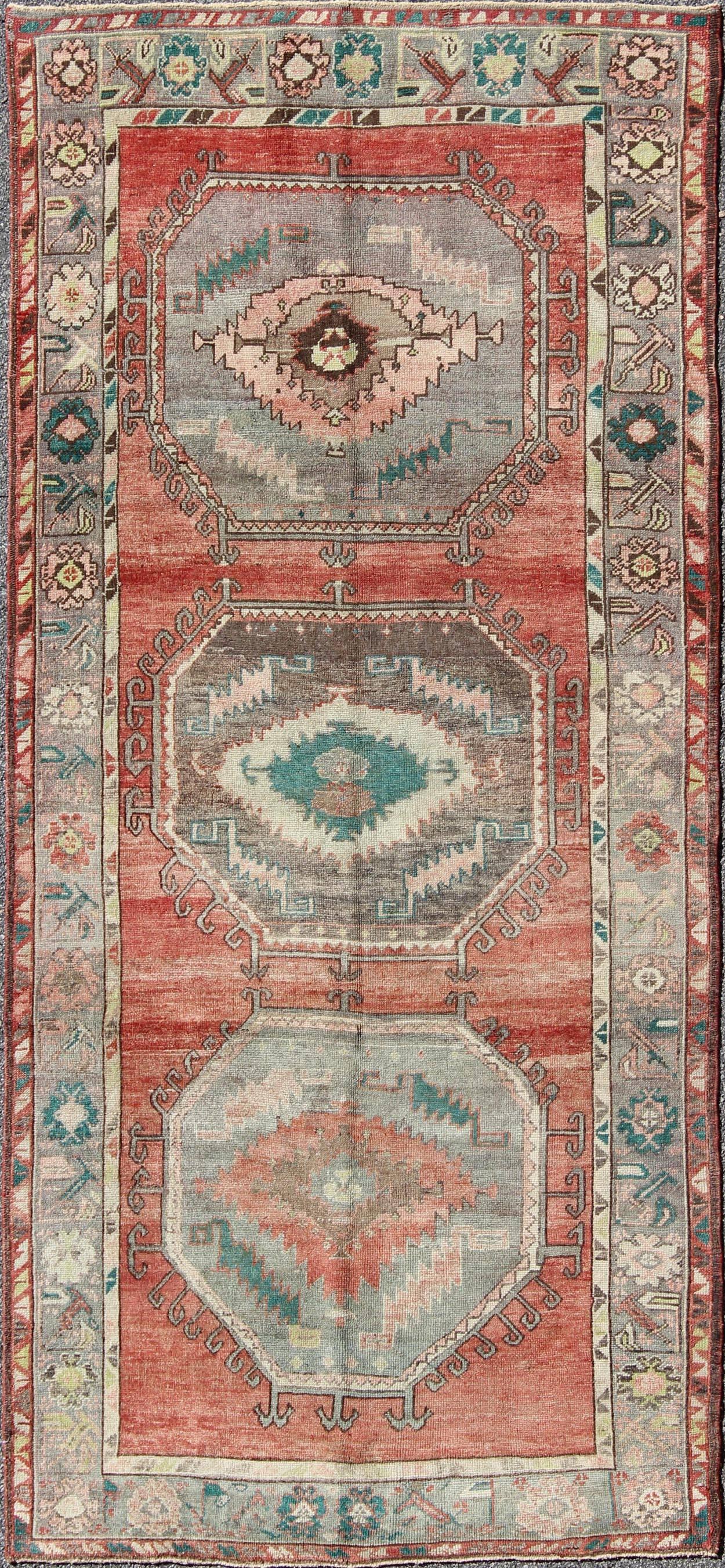This Oushak gallery runner displays archetypal Oushak craftsmanship with a lovely color scheme including subtle tones of coral, taupe, beige, soft green, light teal and purple, which are highlighted by chocolate and mocha colors. The stylized center
