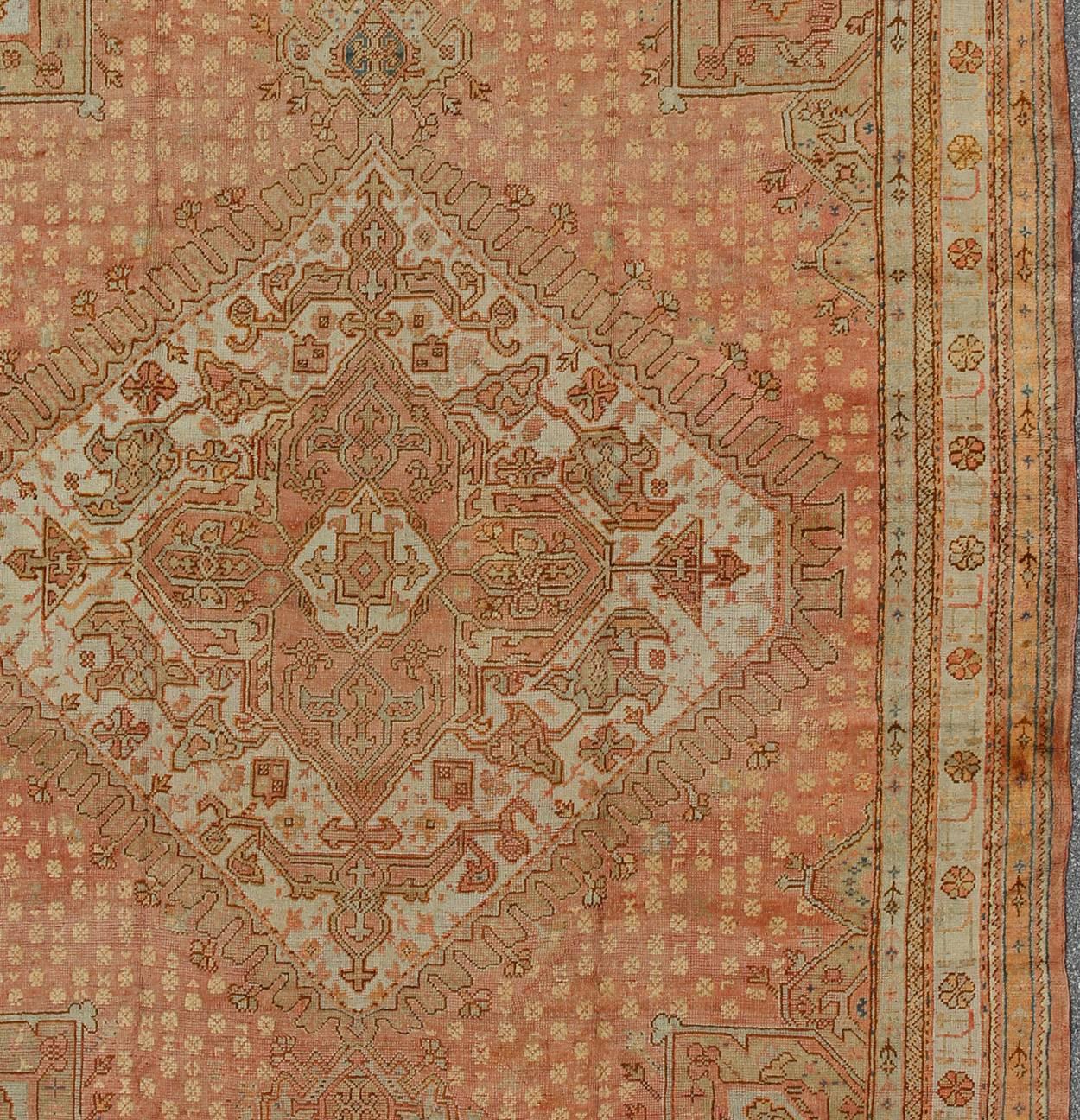 20th Century Antique Turkish Oushak Rug with Geometric Medallion in Salmon Background For Sale