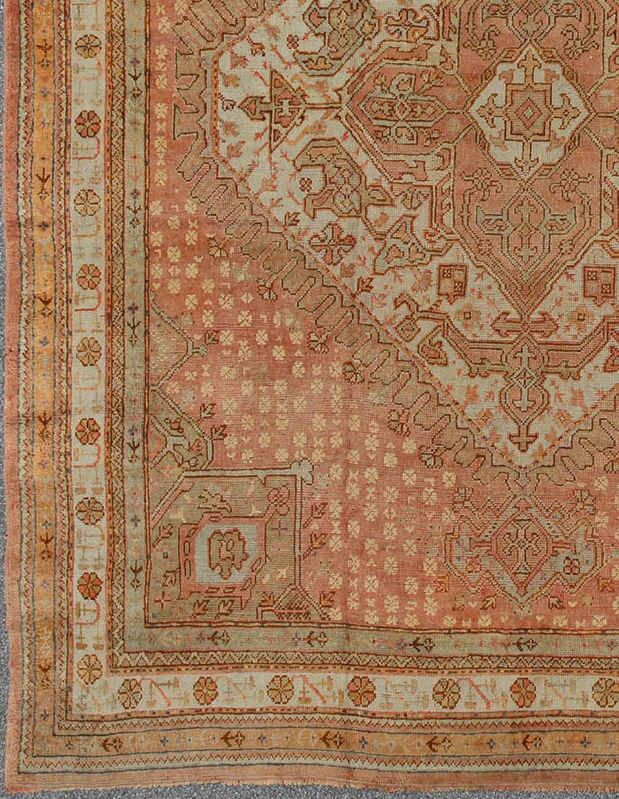 Hand-Knotted Antique Turkish Oushak Rug with Geometric Medallion in Salmon Background For Sale