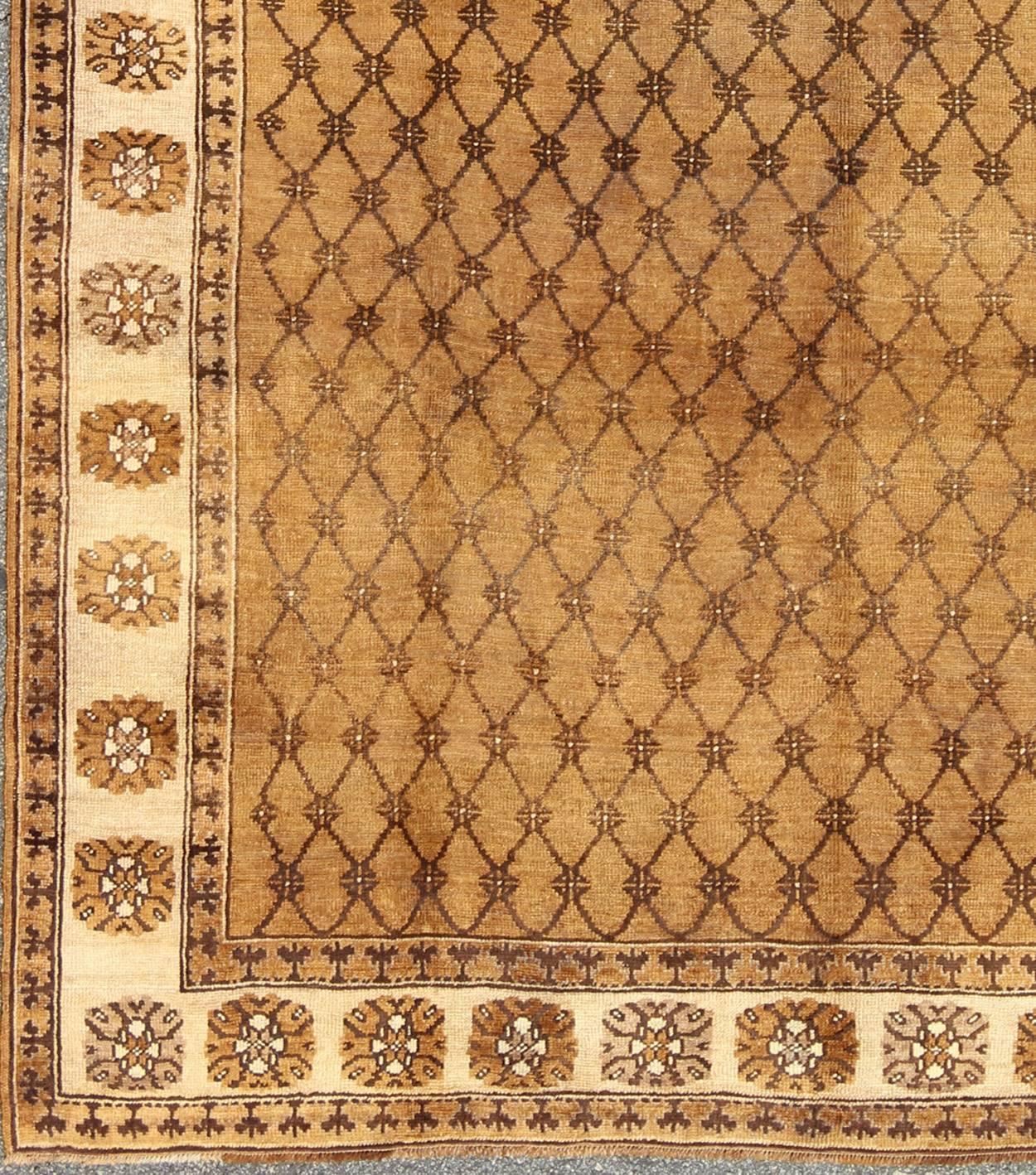 Vintage Turkish Rug in Natural Colors of Brown, Mocha and Cream and a Modern Design
This gorgeous Turkish rug from eastern Turkey features a sophisticated all-over, repeating diamond and blossom pattern. A repeating pattern floral border surrounds