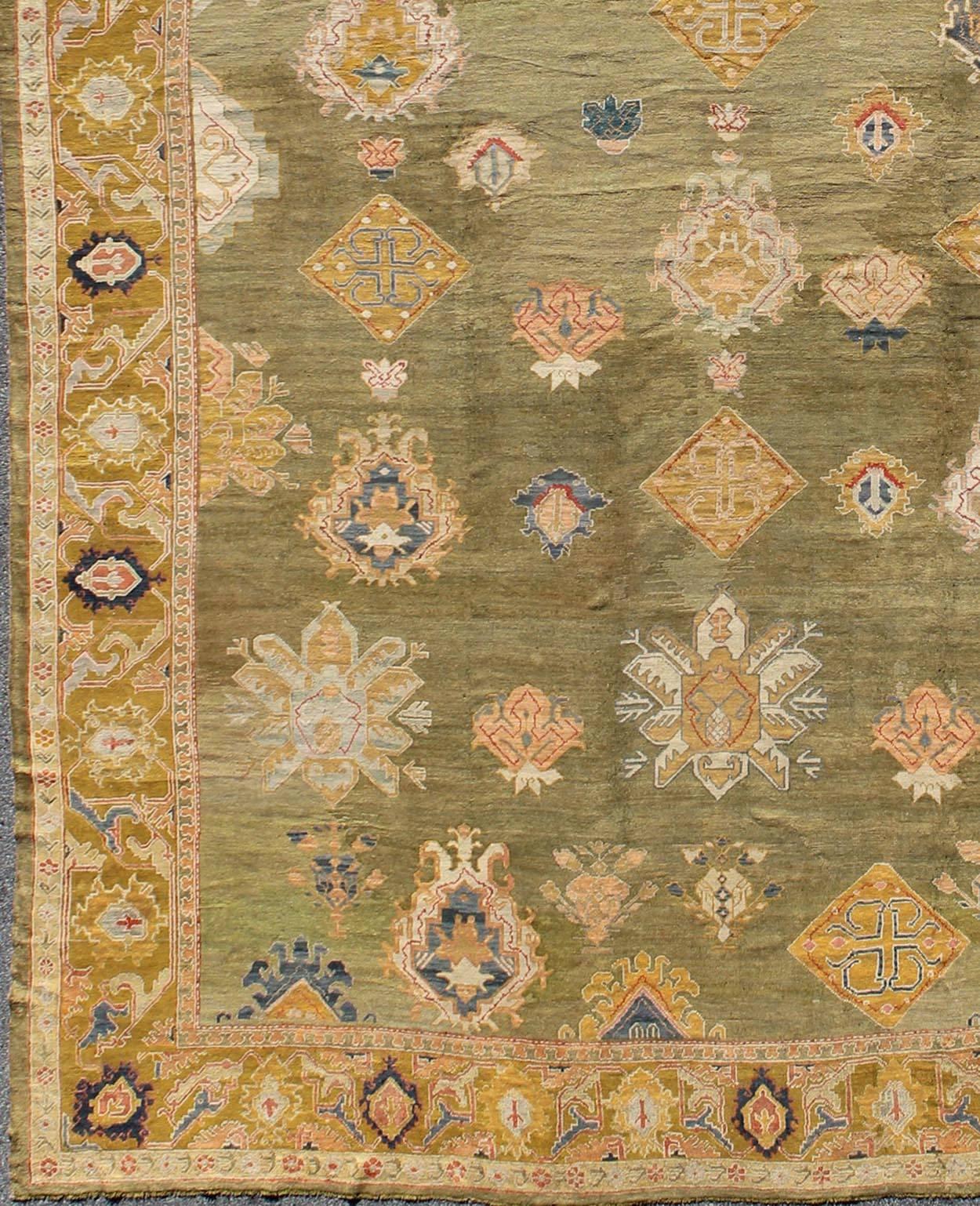 This elegant antique Oushak carpet, of considerably ample size, dates back to around the end of the 19th Century and beautifully illustrates the impeccable craftsmanship and artistry of Oushak weavers. Sumptuously soft woolen threads of green, gold,