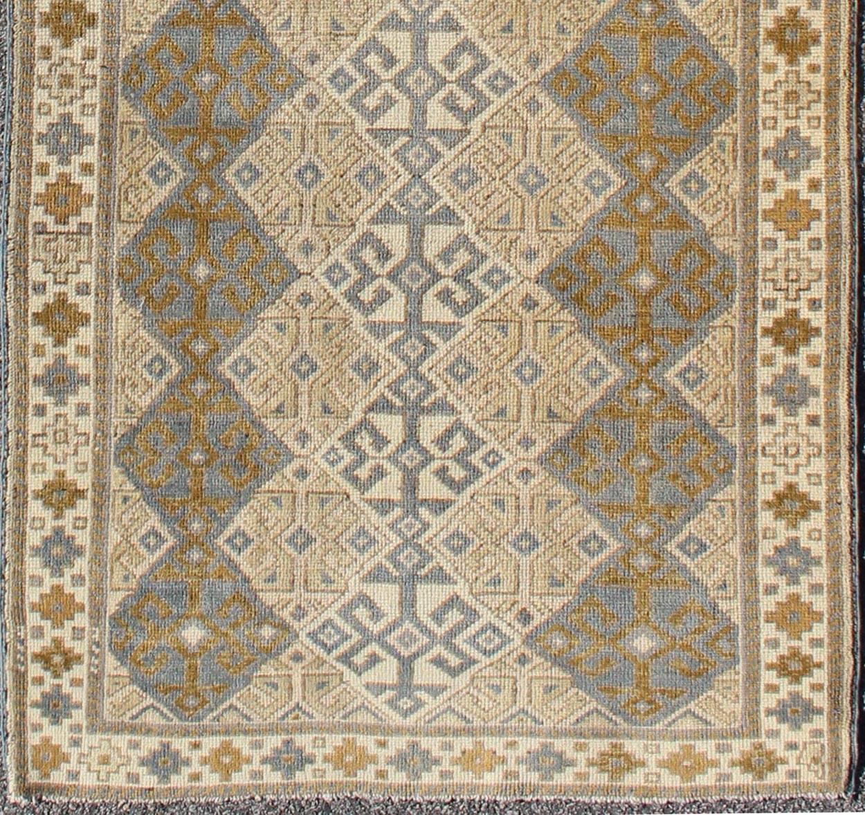 Measures: 3'3 X 9'11.
This rug is composed of alternating diamond motifs in different colorations that make the design more unique. The piece features, Gray blue, Camel, brown, cream and medium blue colors. The border is a Greek key motif that