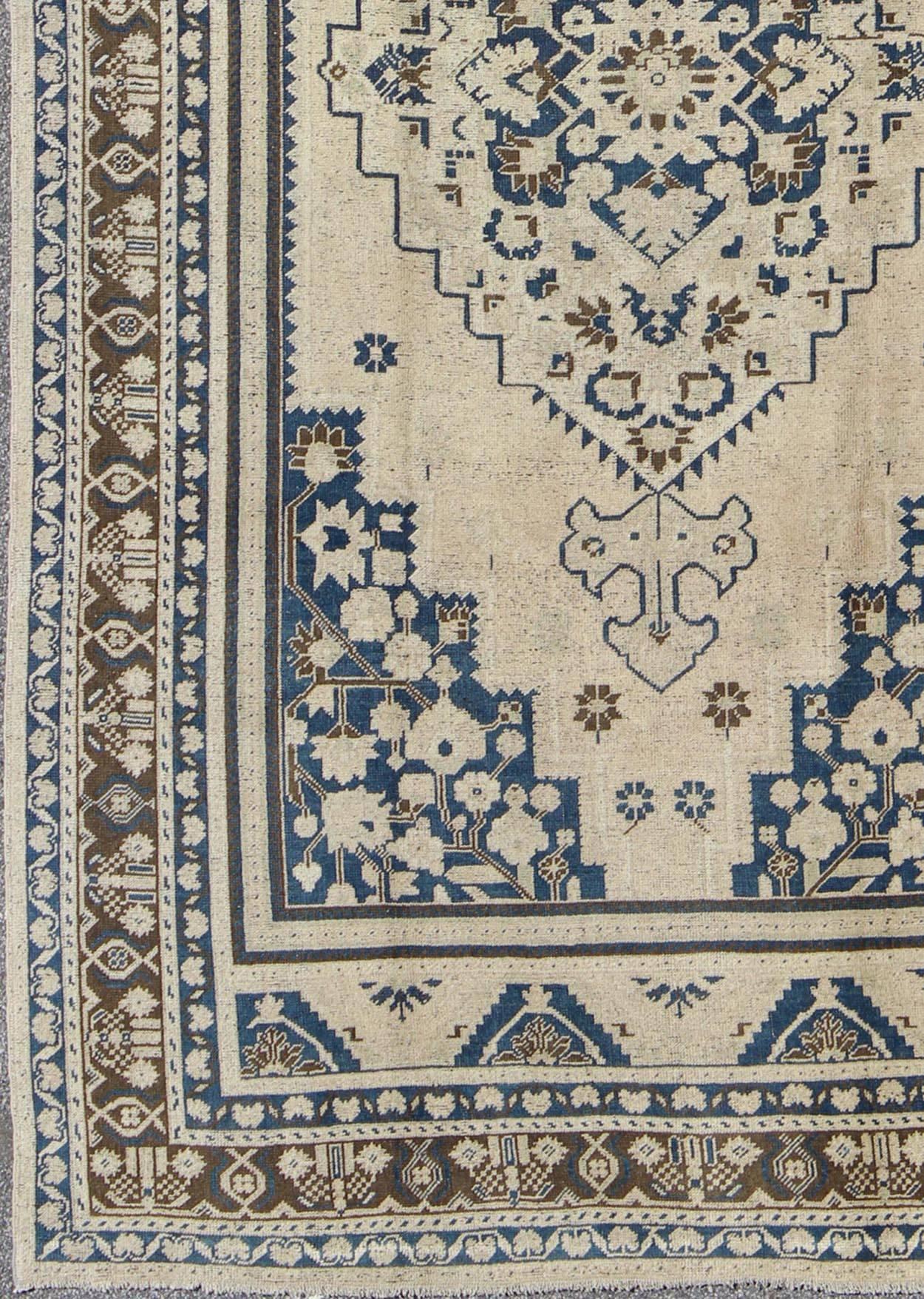 Vintage Turkish Oushak rug with medium blue, steel blue, brown and cream colors, Rug TU-UGU-54, country of origin / type: Turkey / Oushak, circa mid-20th century.

Measures: 6.8 x 11.4

This exquisite vintage Turkish Oushak features a medallion