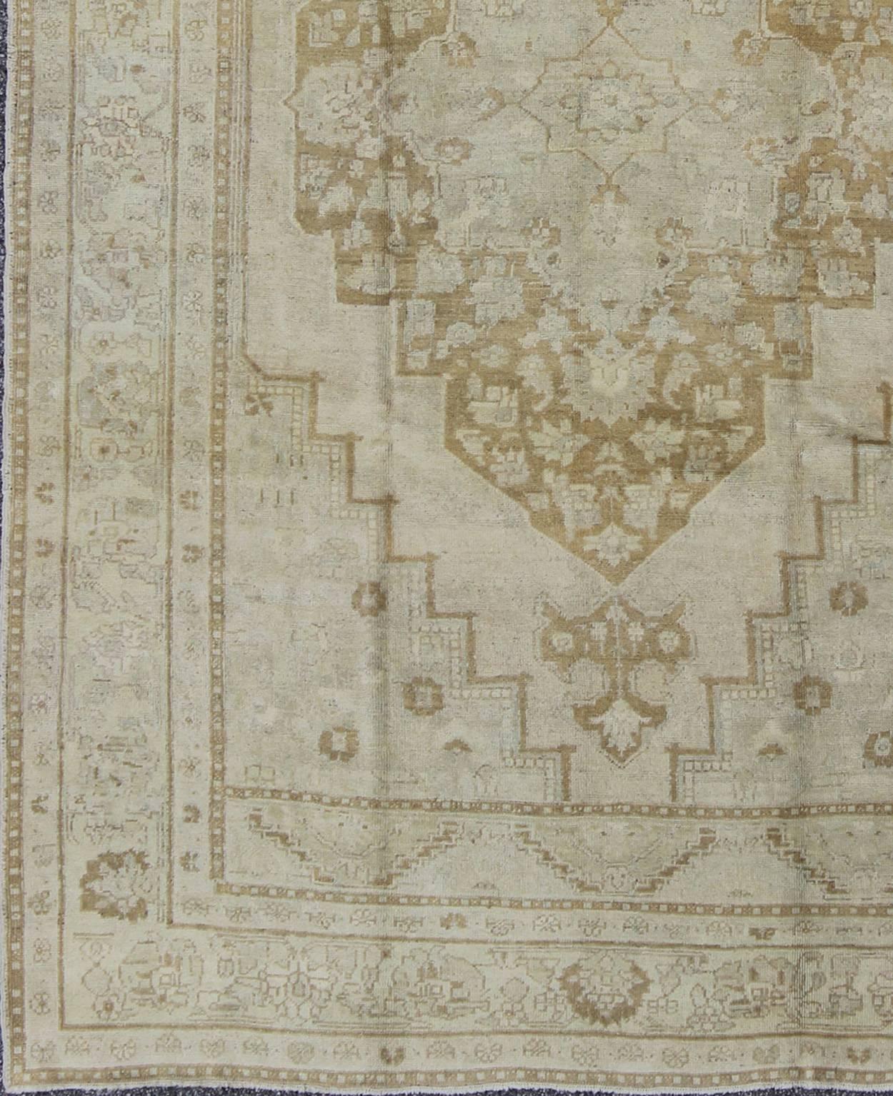 Pale Colored Vintage Turkish Oushak Rug in Gray, Taupe, Cream and Light Brown.
Oushak rugs such as this vintage piece are highly decorative and desirable for their pale colors. The subdued color palette of soft gold, light brown, green, ivory and