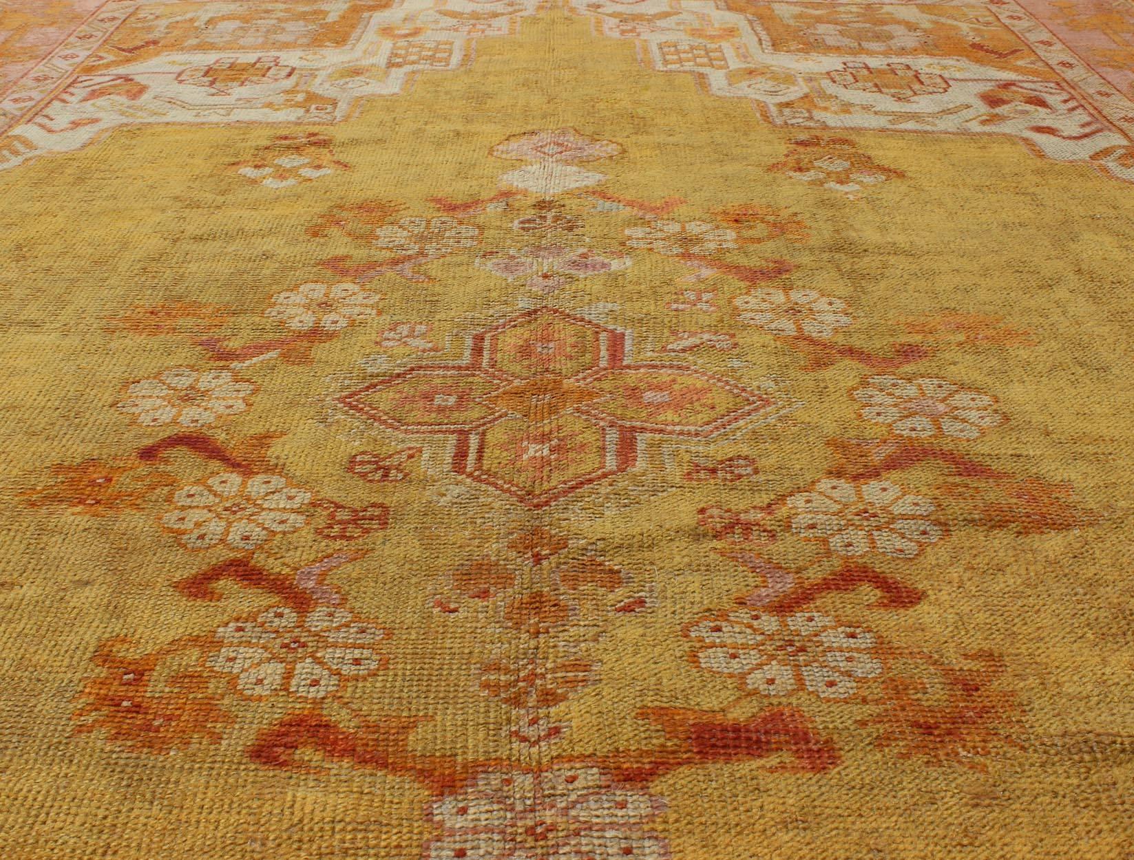 Turkish Antique Oushak Rug in Yellow Green Background, Pink Border, Red & Orange Accents For Sale