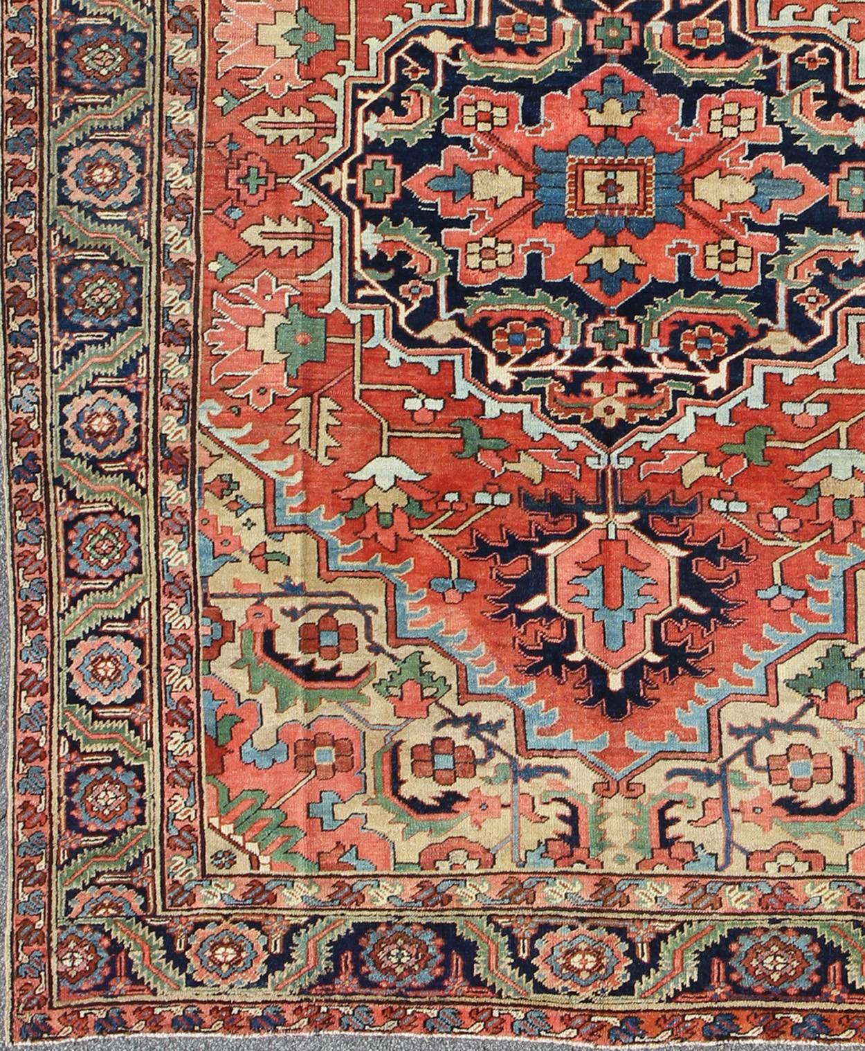 This beautiful antique Heriz-Serapi, produced in Iran in 1910, displays a bold and dynamic design. The color palette of this piece, including various tones of red, yellow, green, blue, teal and ivory, establishes it as an exemplary rug of its