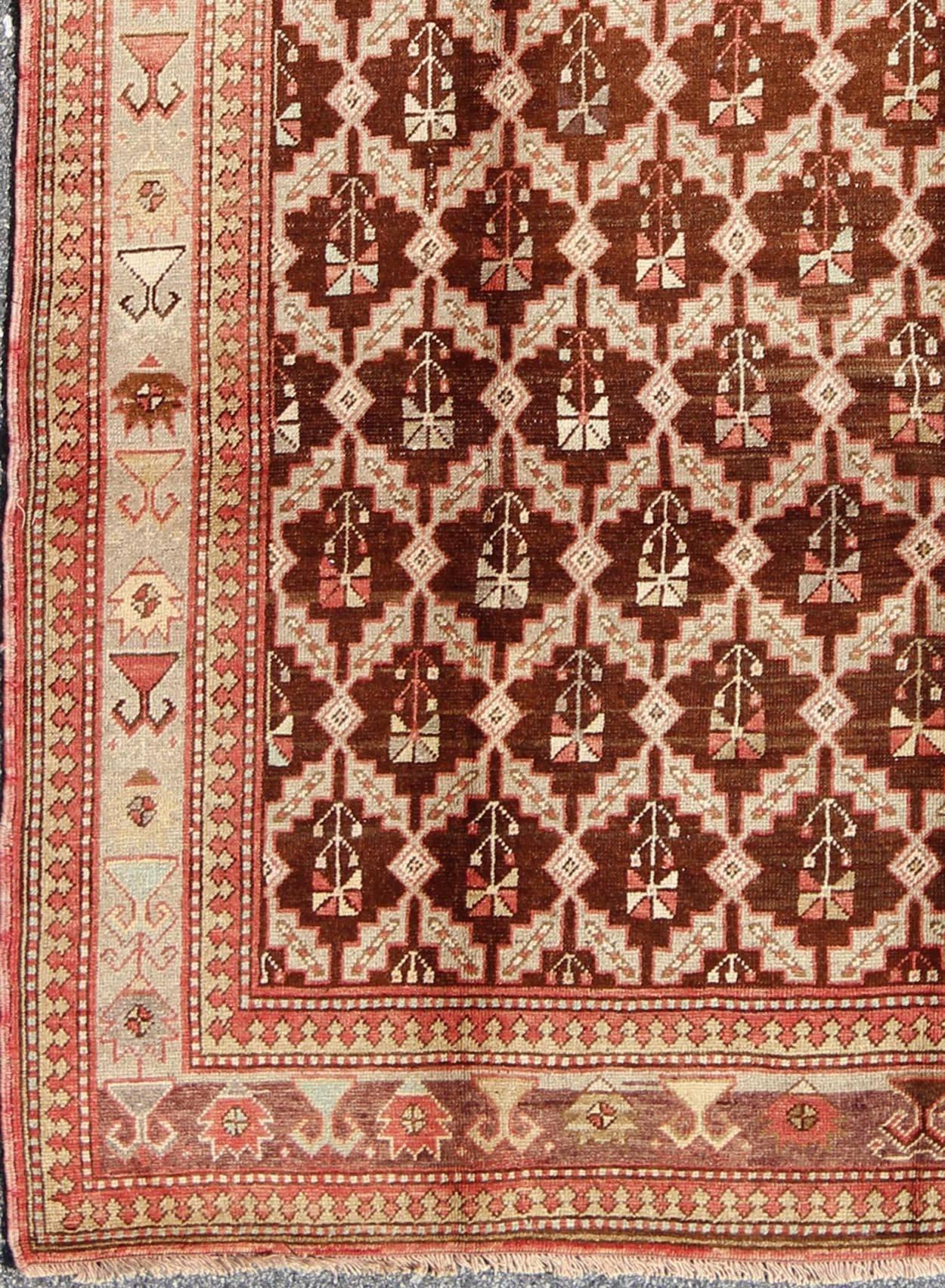 This wonderful Turkish Oushak has a chocolate brown background and a repeating pattern. Coral and ivory with hints of green make this a unique piece of art. The border motifs consist of Butter, pale blue, coral and very pale green.

Antique