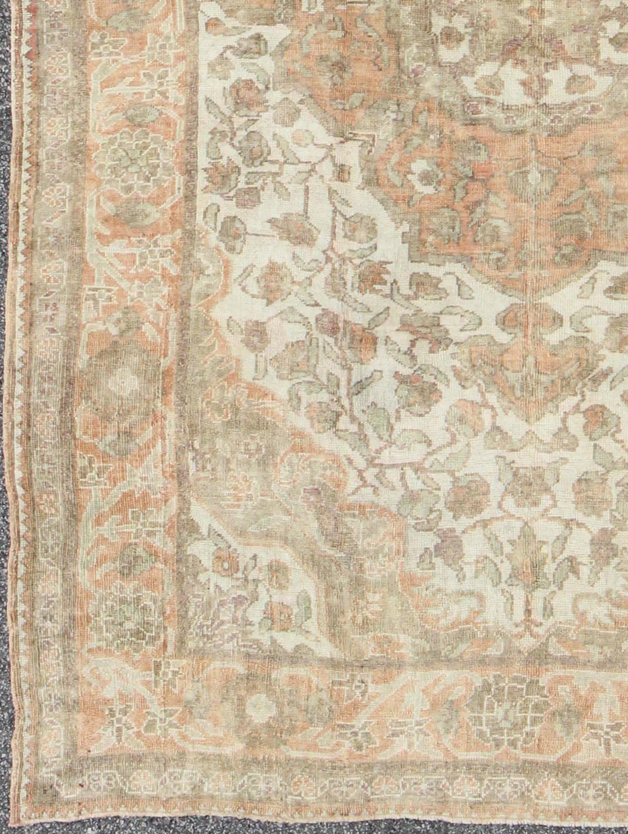 Measures: 6'9 x 9'3

This wonderful medallion Oushak features a soft color palette. The border has flowers connected by vines while the field also features a flower pattern. The colors are earth-toned and muted, including peach, tan, ivory, light