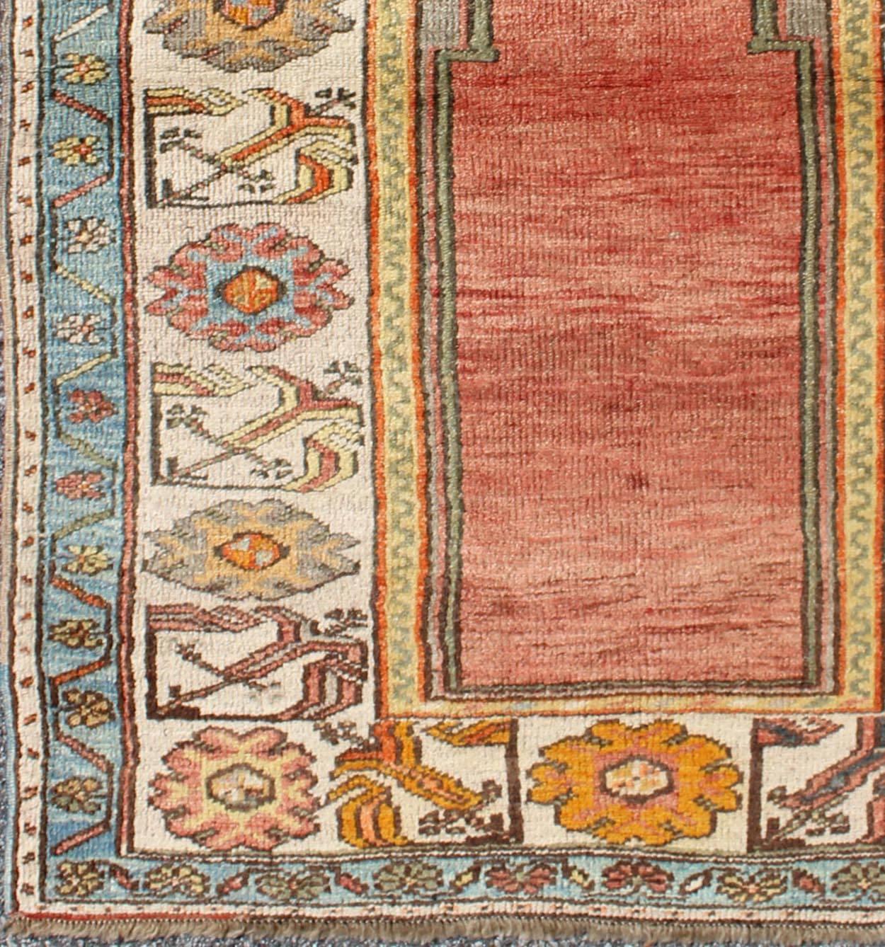 Antique Turkish Prayer Rug in Turquoise, Salmon, Orange, Blue and Ivory.
This wonderful, small prayer rug displays a multi-tiered, wide border and a prayer design. The striking colors of 
 turquoise, Salmon, Orange give this very unique design much