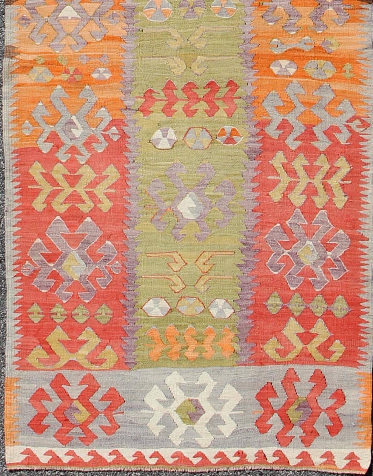 Long Kilim Runner with Tribal Design in Yellow Green, Red and Orange.
Set on a citron-green background, this long vintage runner displays a unique color combination and design, rendered in various motifs.
Measures: 3' x 14'2.