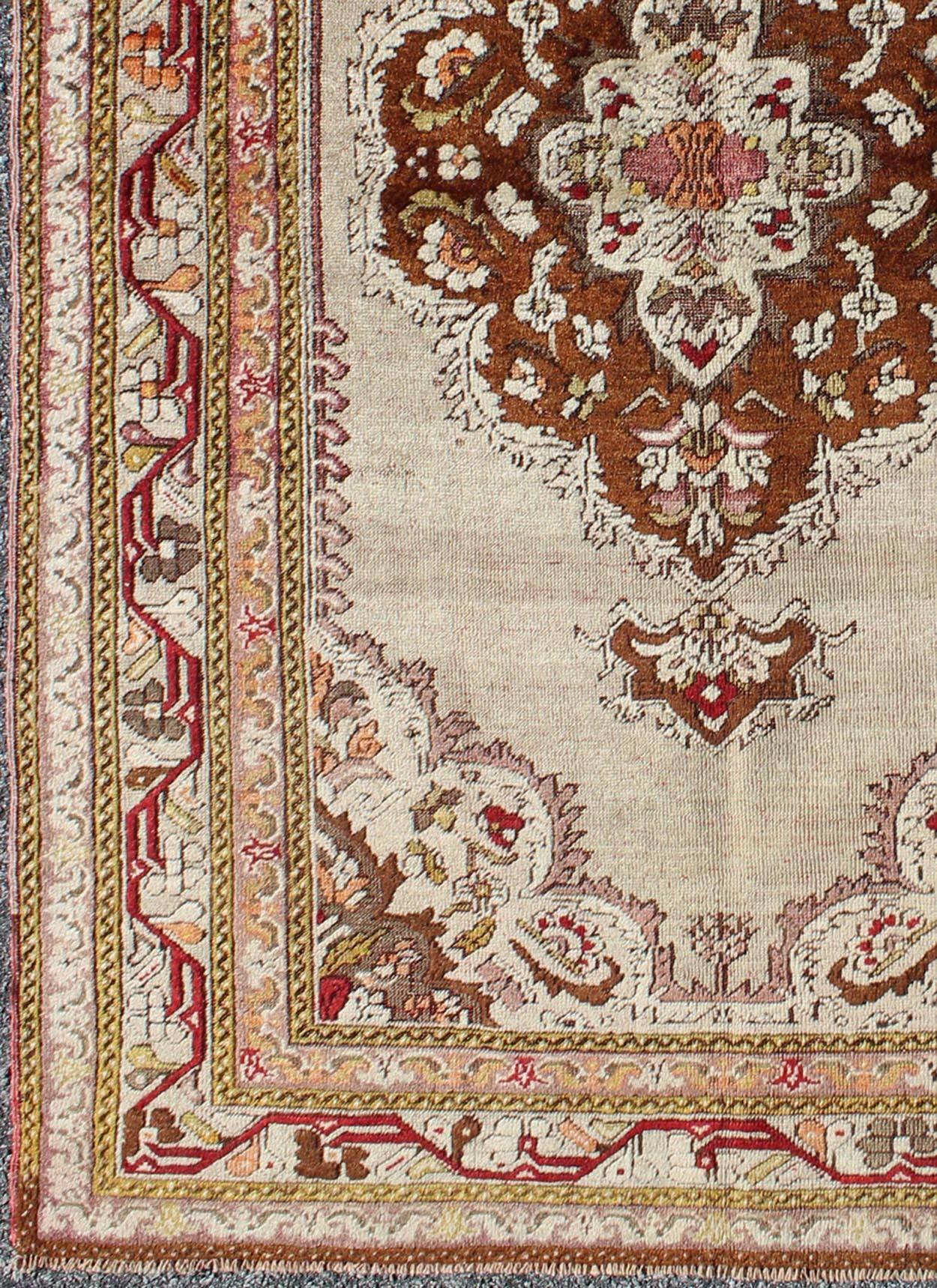 Antique Turkish Oushak with Brown Medallion and Taupe Background in Matti shades of green, and Red Accents, Rug TU-EMD-95032, country of origin / type: Turkey / Oushak, circa early-20th Century.
Measures: 4'2 x 6'9.
Antique Oushak Rugs are