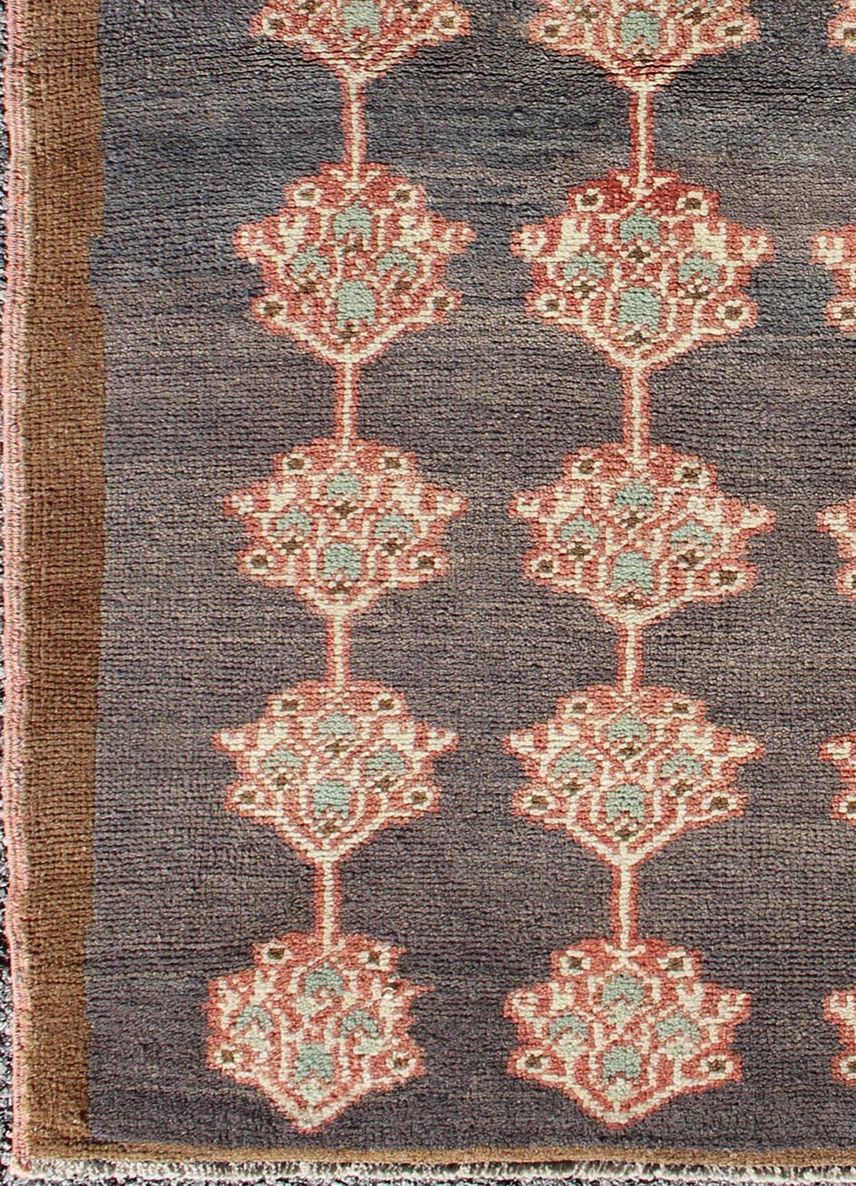 Turkish Tulu with three rows of Floral Medallions, rug EN-142681, country of origin / type: Turkey / Tulu, circa mid-20th Century.

This Tulu carpet features three rows of medallions laid across a charcoaled -colored field and enclosed within a