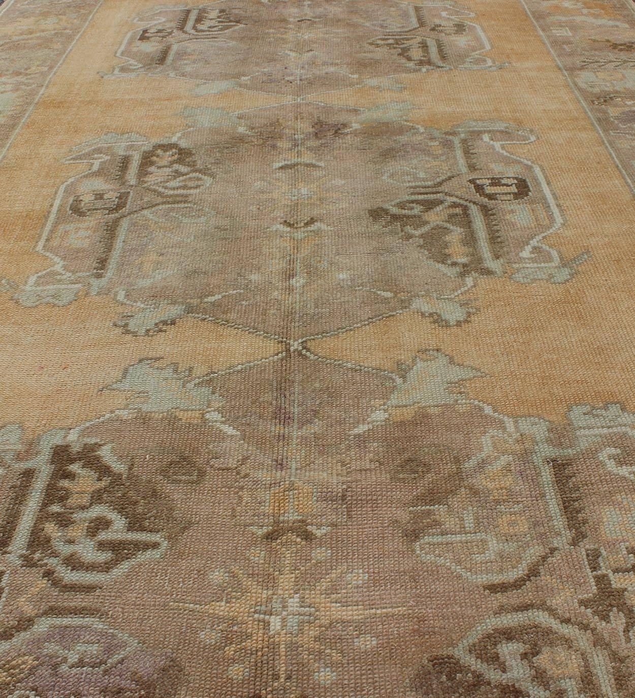 Alfombra antigua Oushak con tres medallones centrales sobre un campo de color arena tenue siglo XX en venta